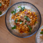 Mexican Street Corn Casseroles in glass bowls with visible corn and rice.