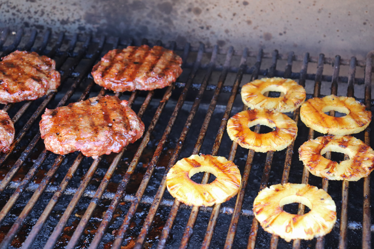 Teriyaki Burgers on the grill with pineapple rings.