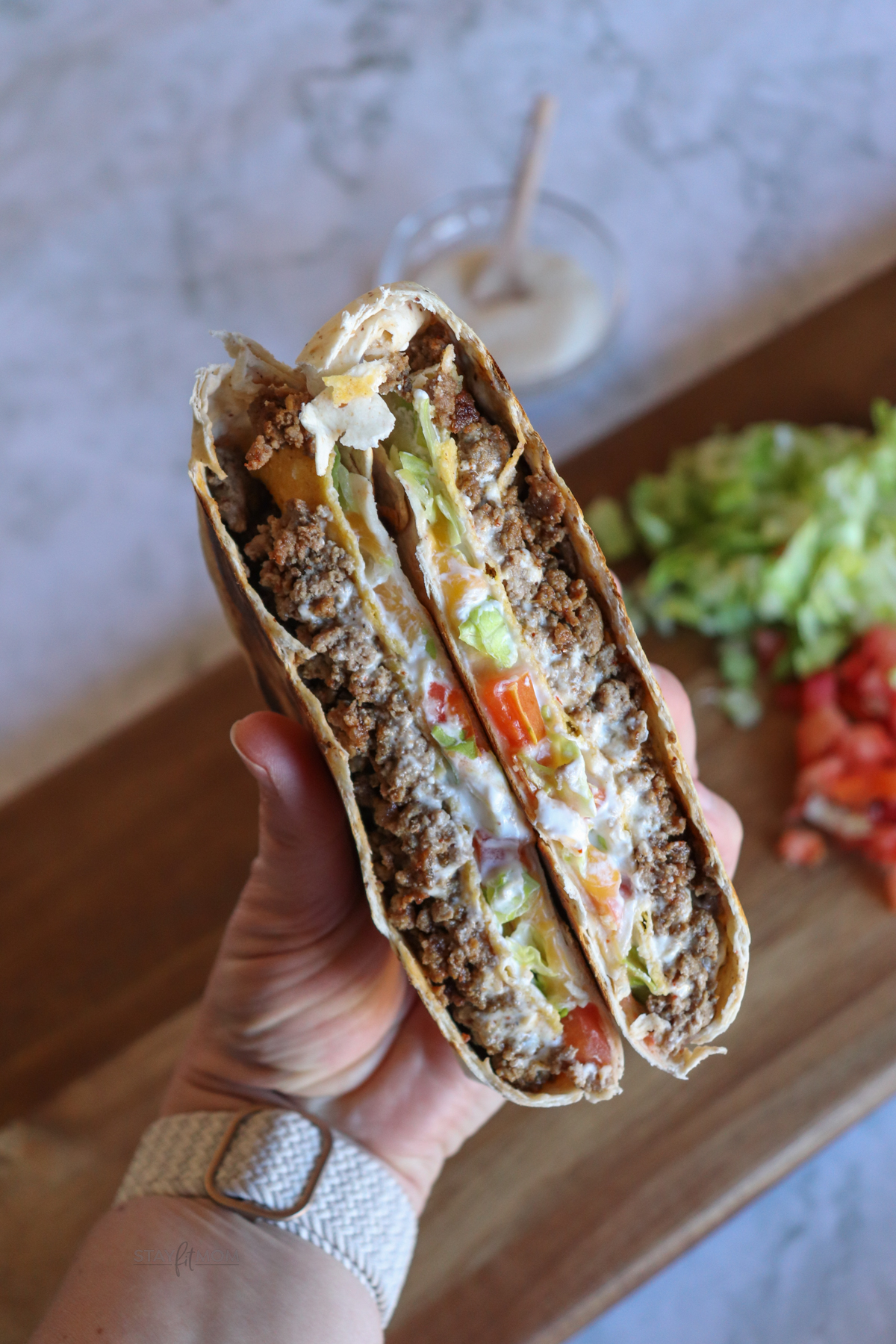 Crunch Wrap Supreme cut in half showing the insides.