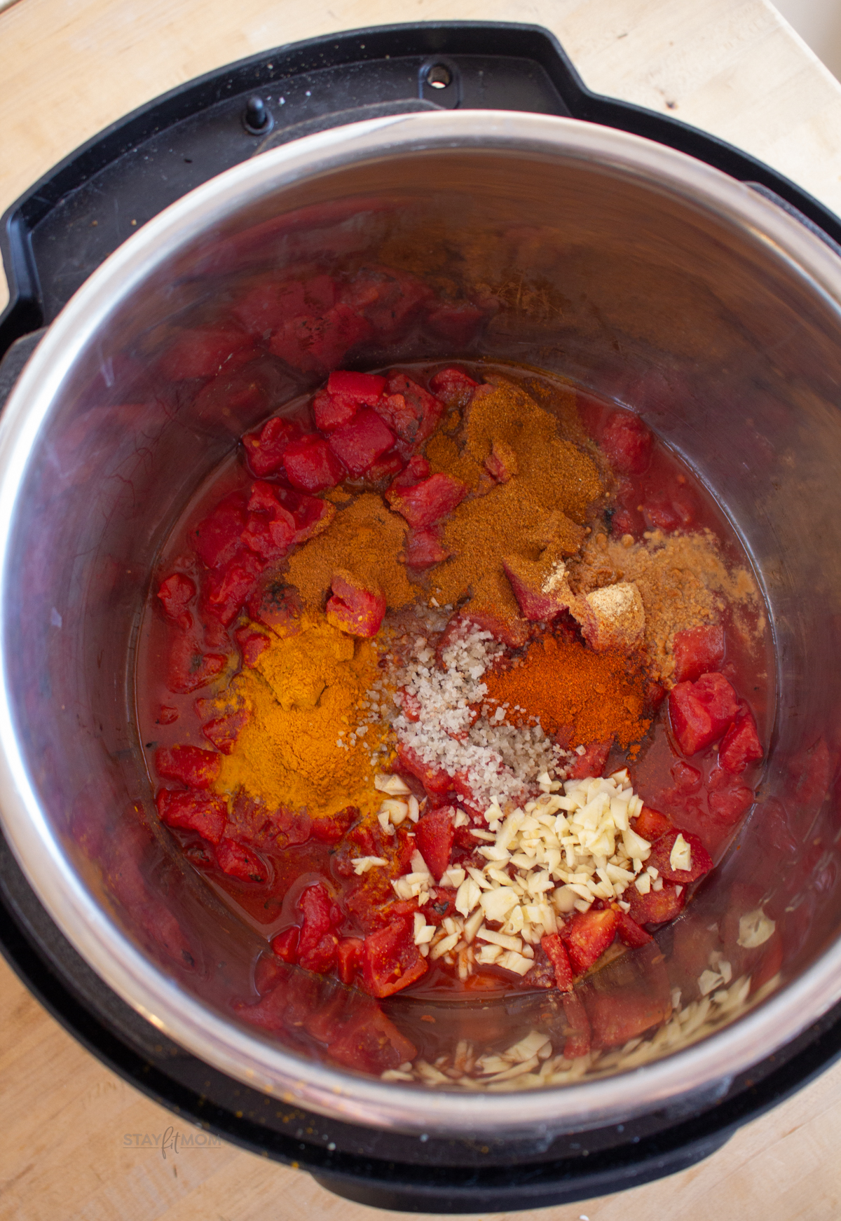 Butter chicken showing instant pot with water and spices.