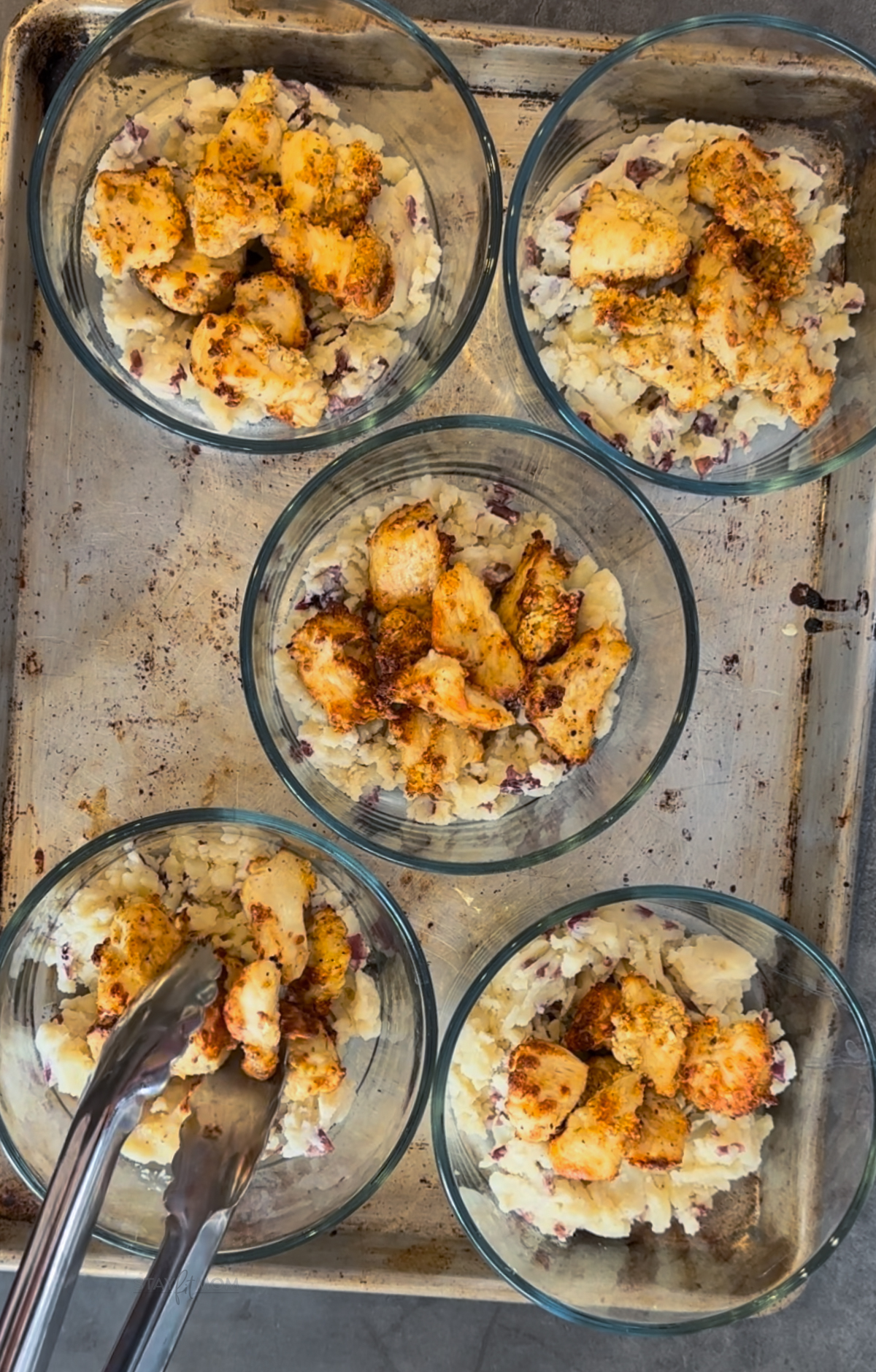 KFC Bowls showing bowls with potatoes and being topped with chicken.