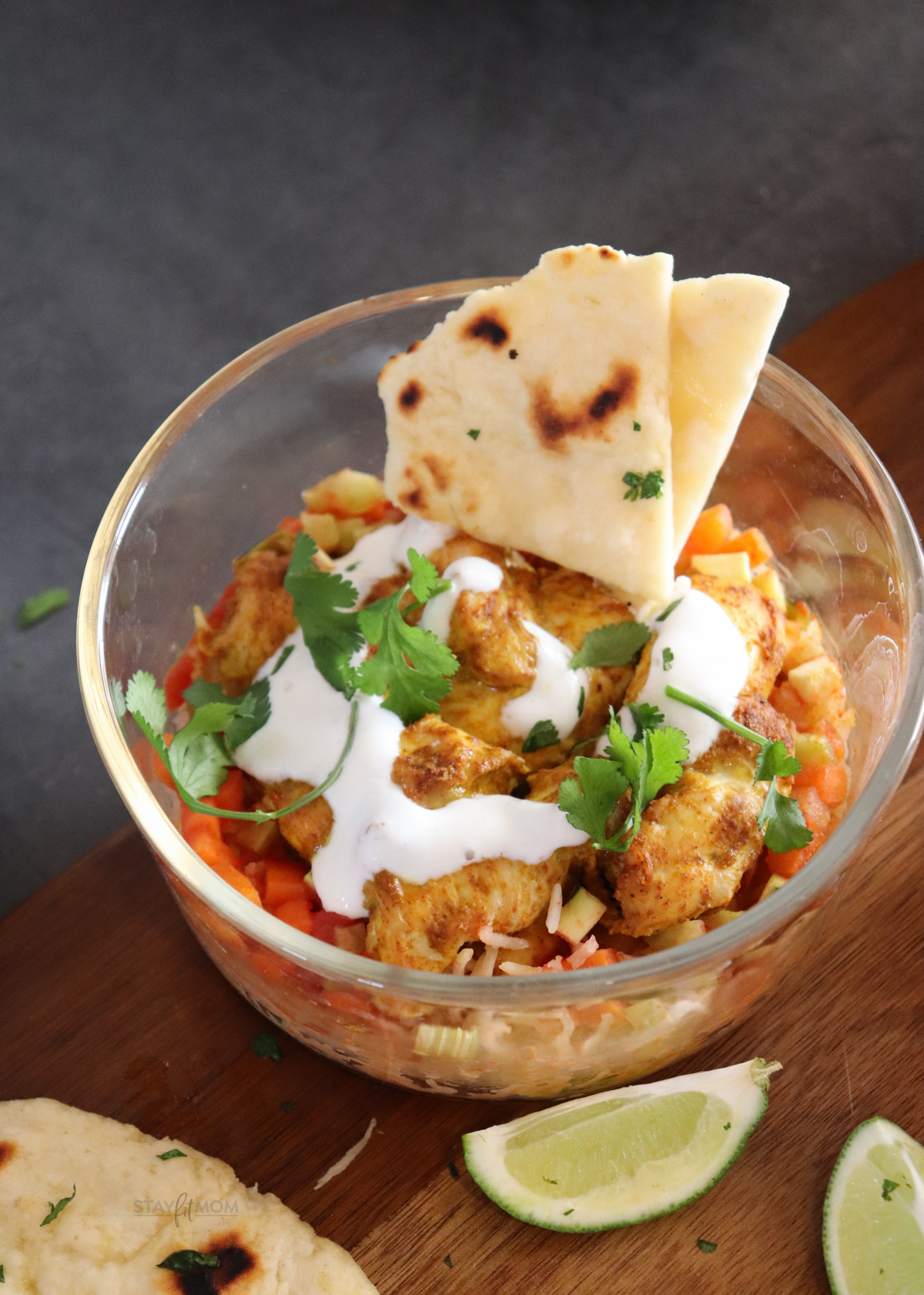 Butter chicken bakes showing completed meal with visible chicken, naan, veggies, sauce, topped with cilantrol