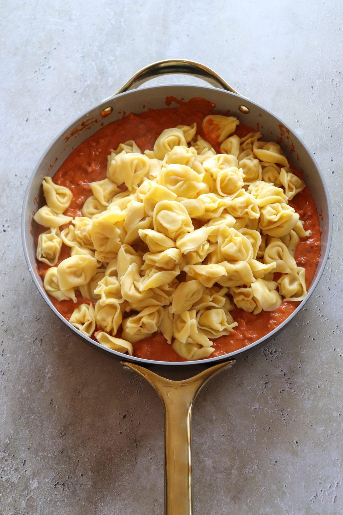 Chad's Easy Tortellini showing sausage and marinara topped with cooked tortellini.