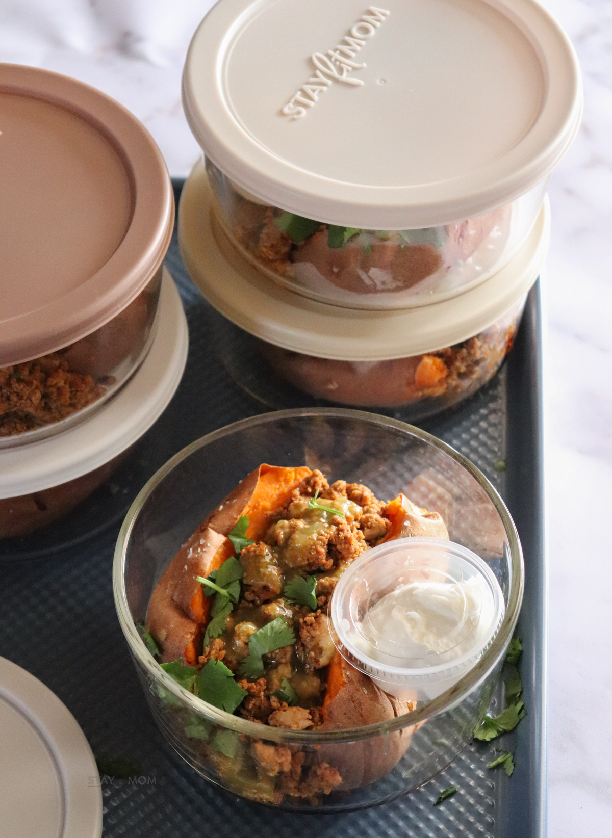 Baked sweet potato bowls showing meal prep bowl with sweet potato topped with ground turkey and green salsa with a side of Greek yogurt.