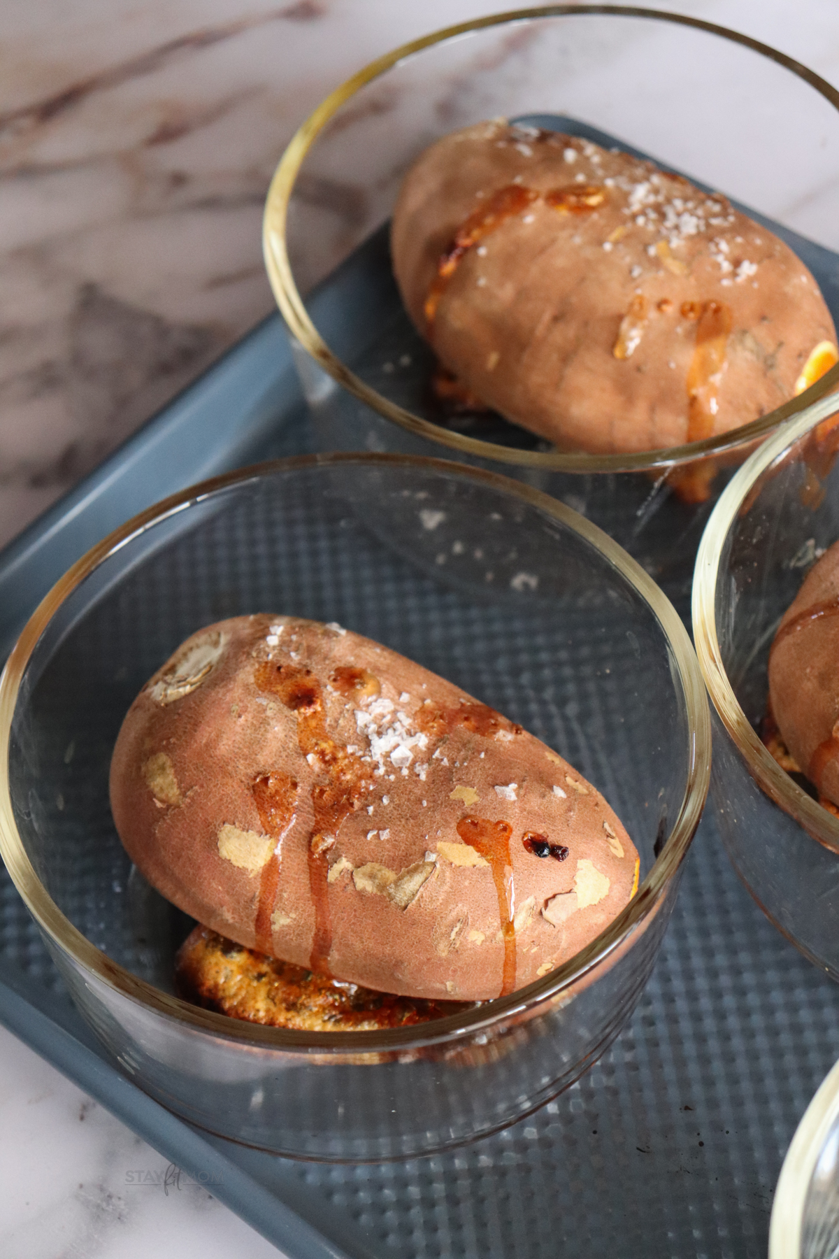 Baked Sweet Potato Bowls showing cooked sweet potato in glass meal prep bowl.