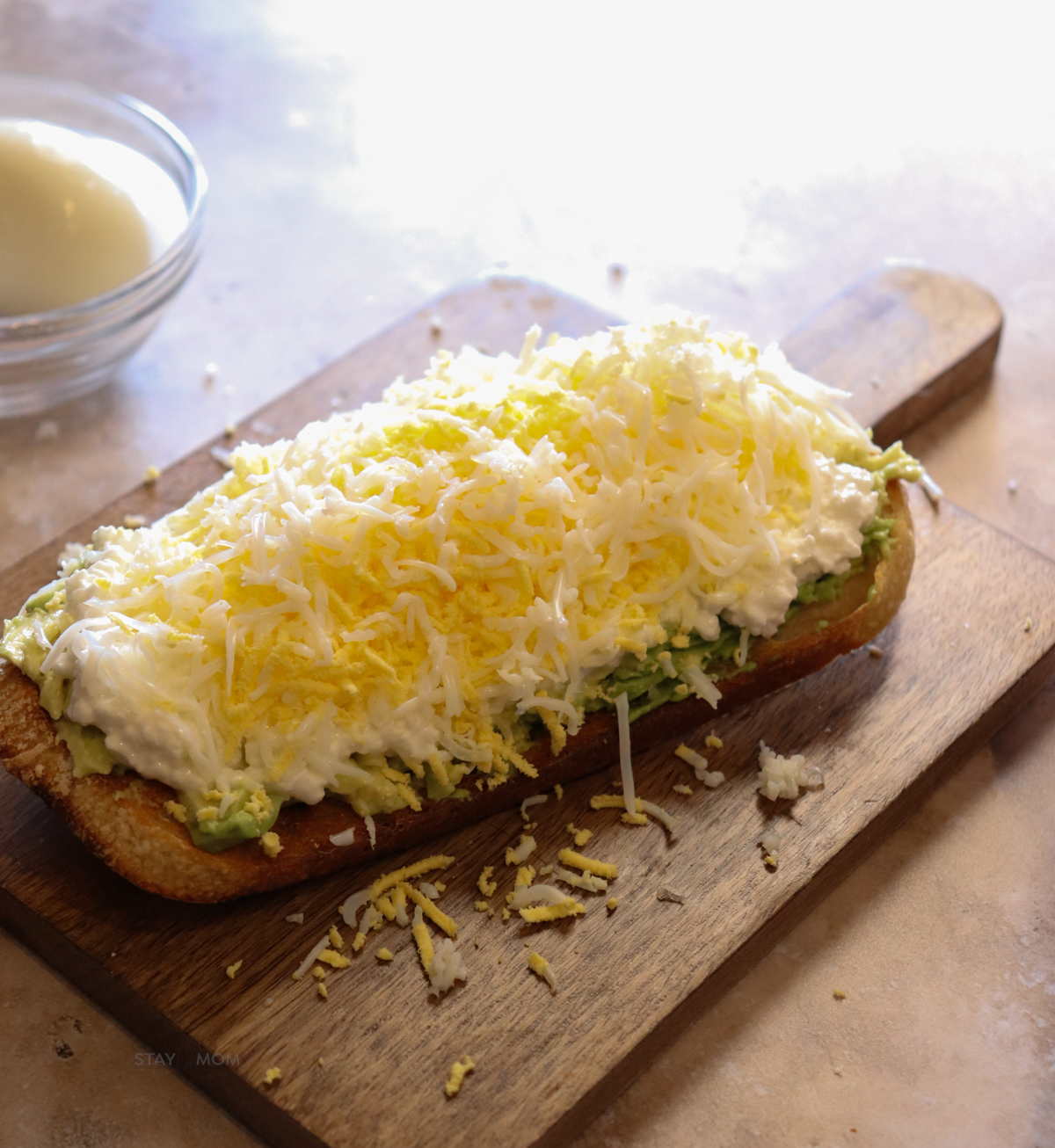 Sourdough toast with avocado, cottage cheese, and shredded egg on top.