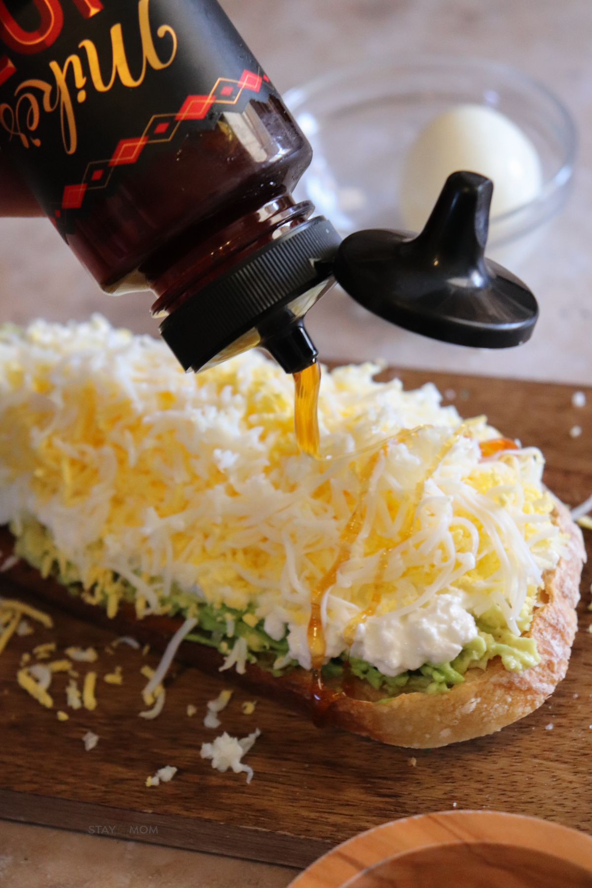 Shredded Egg Sourdough Toast wit hot honey being drizzled on top.