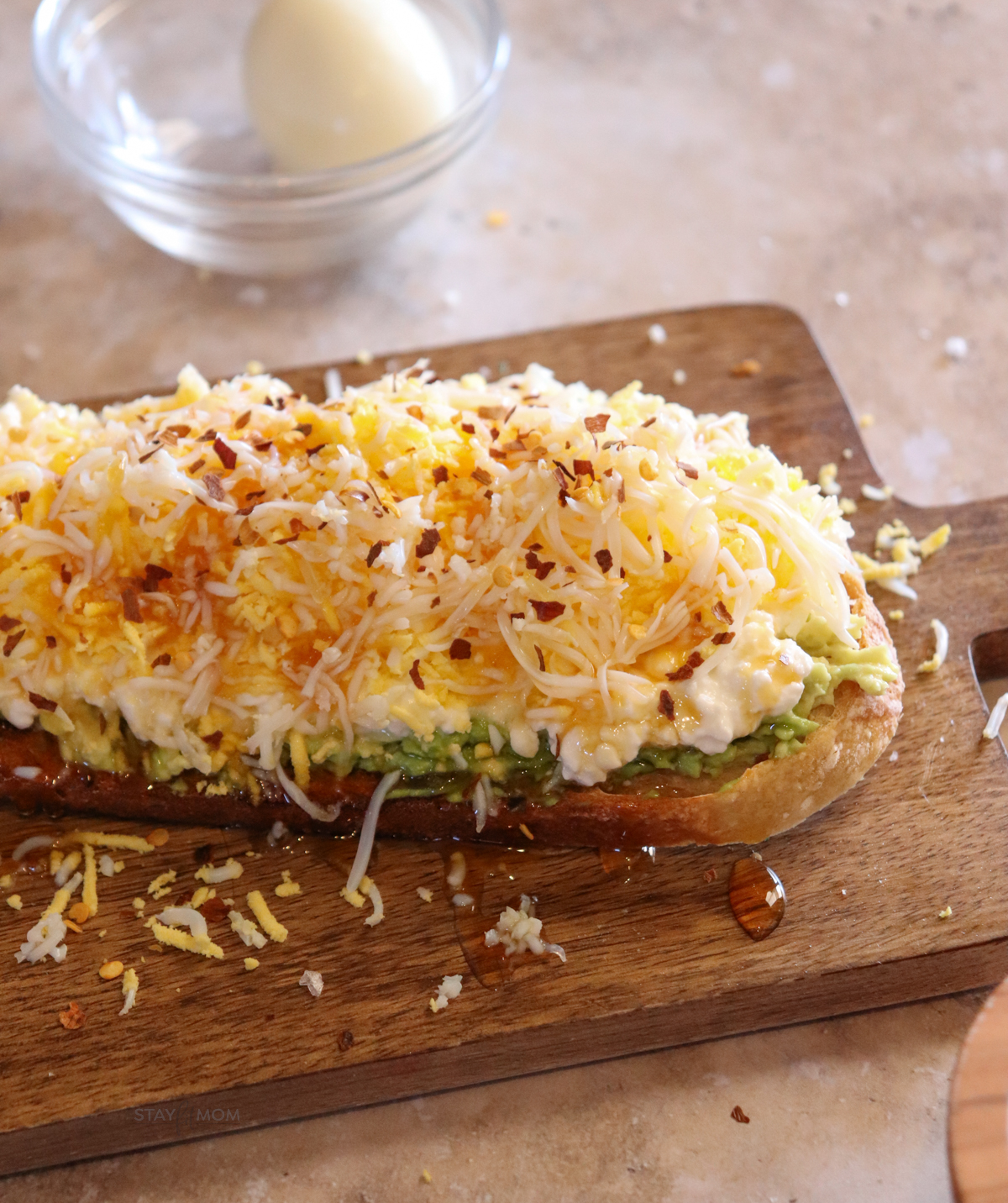 Shredded egg sourdough toast showing completed toast with visible sourdough, avocado, cottage cheese, shredded egg, honey, and red pepper flakes.