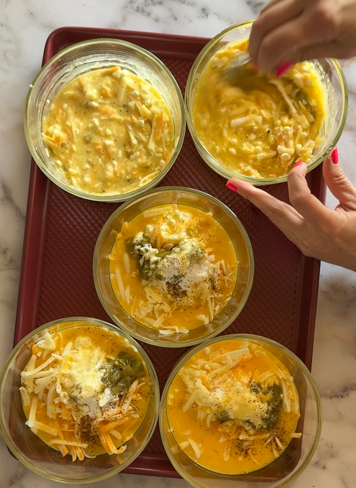 Green Chile Egg Casseroles being stirred together before baking.