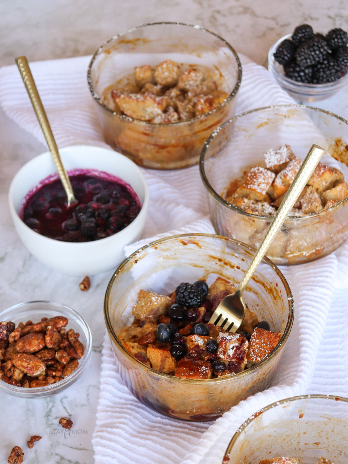 French Toast Bakes showing completed recipe being drizzled with syrup and with small bowls of topping ideas around it.