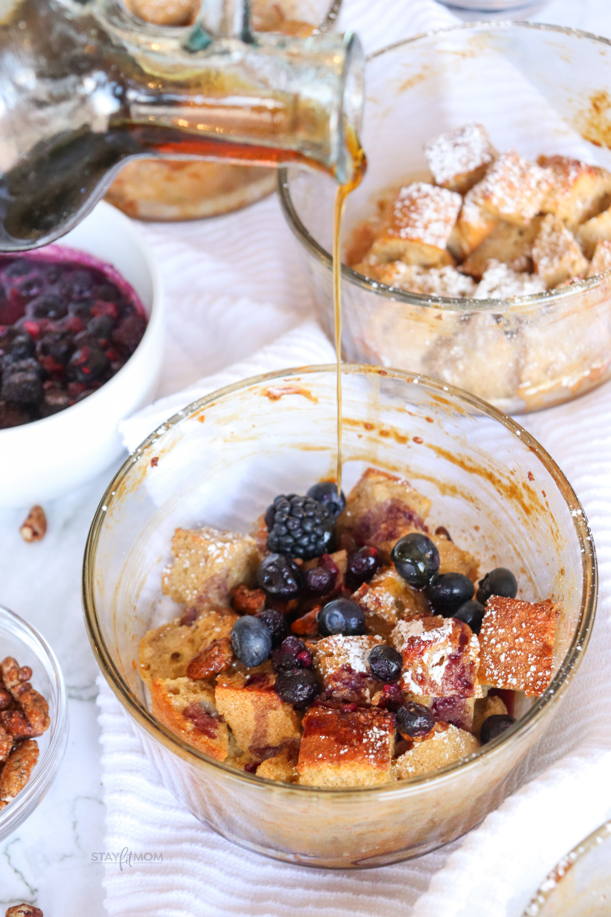 French Toast Bakes showing completed recipe in meal prep bowl topped with berries and syrup.