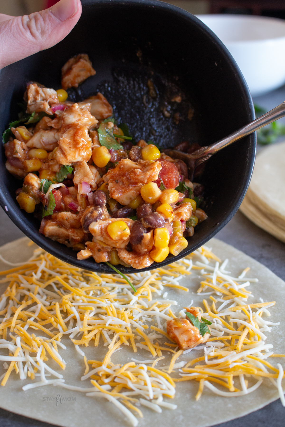 Cowboy Quesadillas showing raw tortilla topped with cheese and the bbq chicken mixture being poured on.