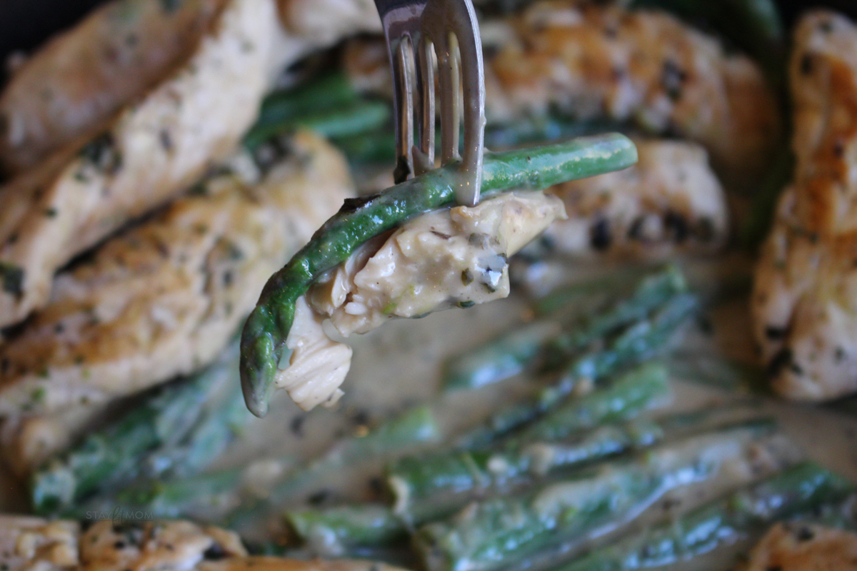 Creamy Garlic Basil Chicken showing a close up view with a forkful of chicken & asapragus.