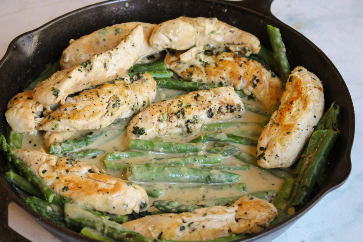 Creamy Garlic Basil Chicken showing completed meal with chicken tenders, asparagus, and a creamy sauce.