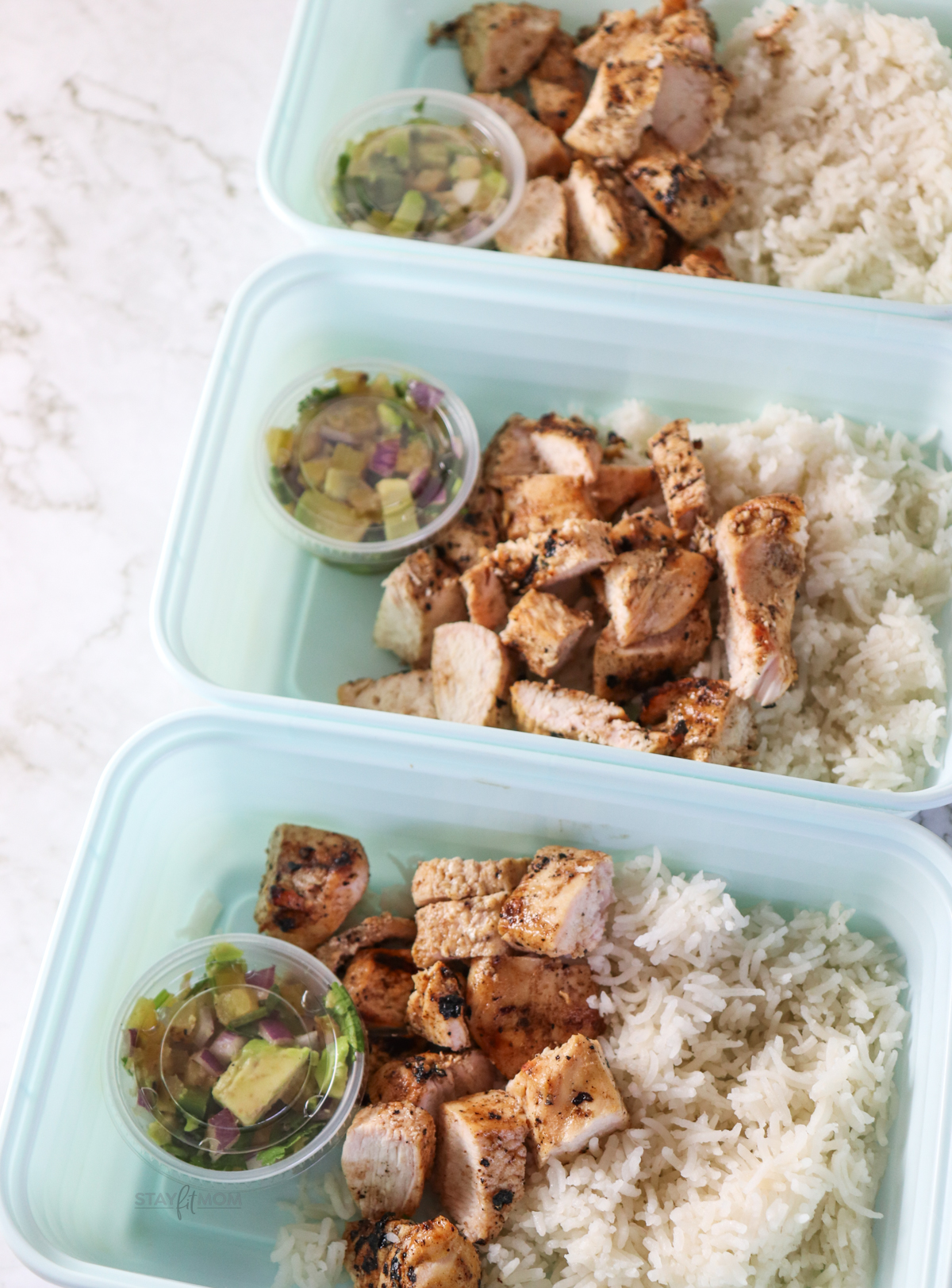 Hawaiian Chicken Bowls showing completed meal with visible cooked rice, chopped grilled chicken, and avocado salsa.