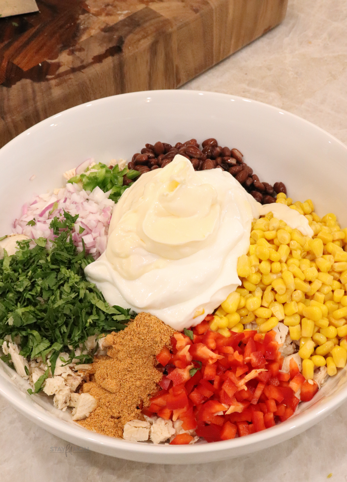Frito Chicken Salad showing all ingredients in a bowl ready to be stirred together.