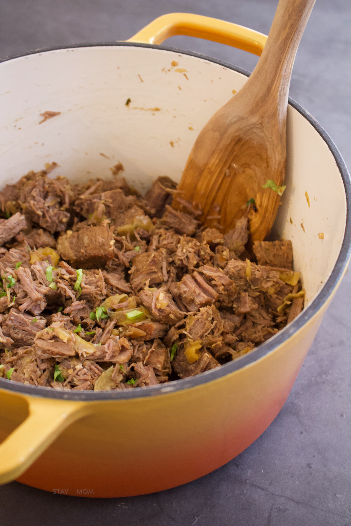 Mississippi Pot Roast showing completed recipe with shredded beef and chunks of pepperocinis.