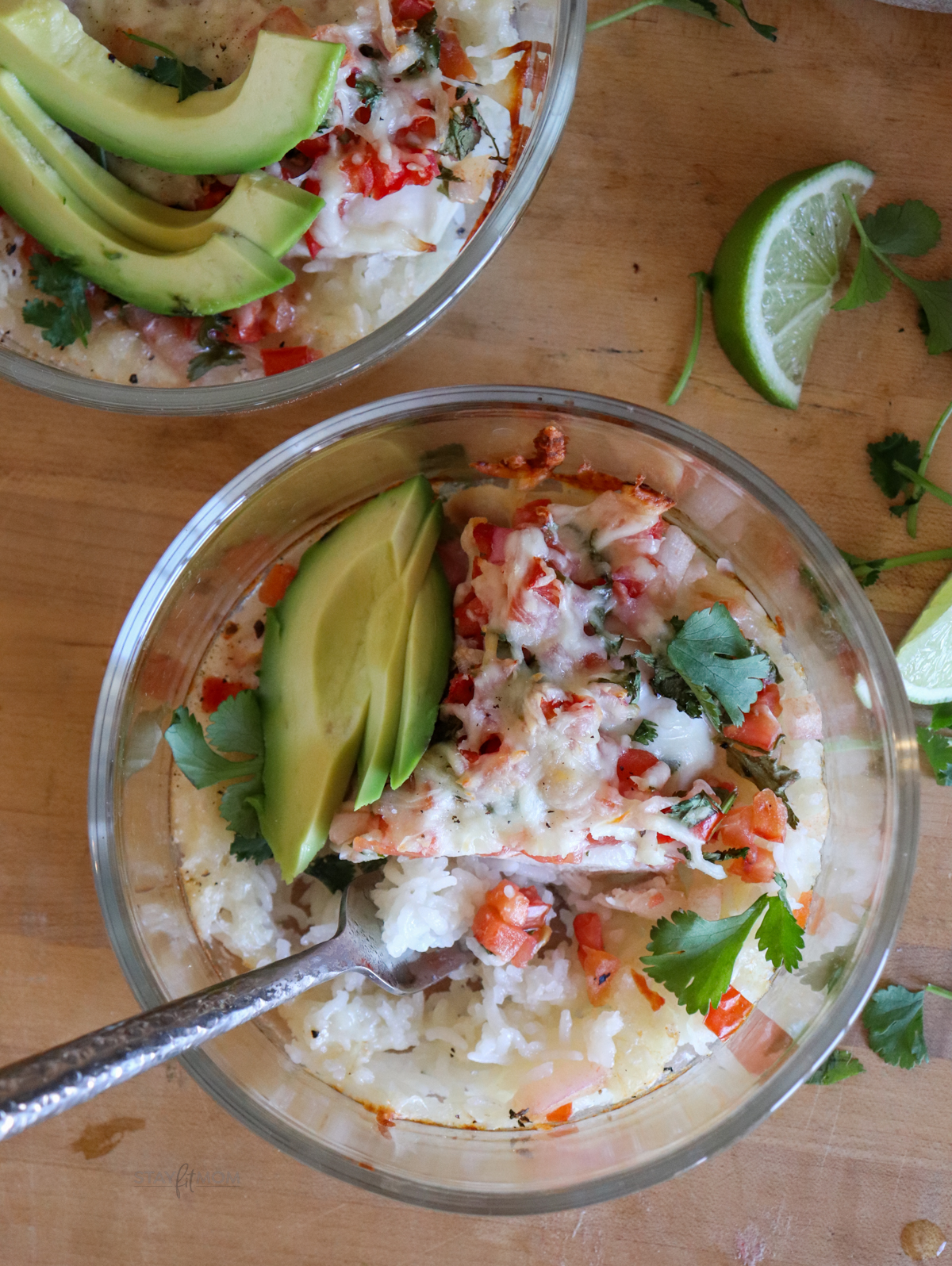 Salsa Fresca Chicken meal prep completed recipe with visible rice, salsa, melted mozzarella and topped with avocado and cilantro.