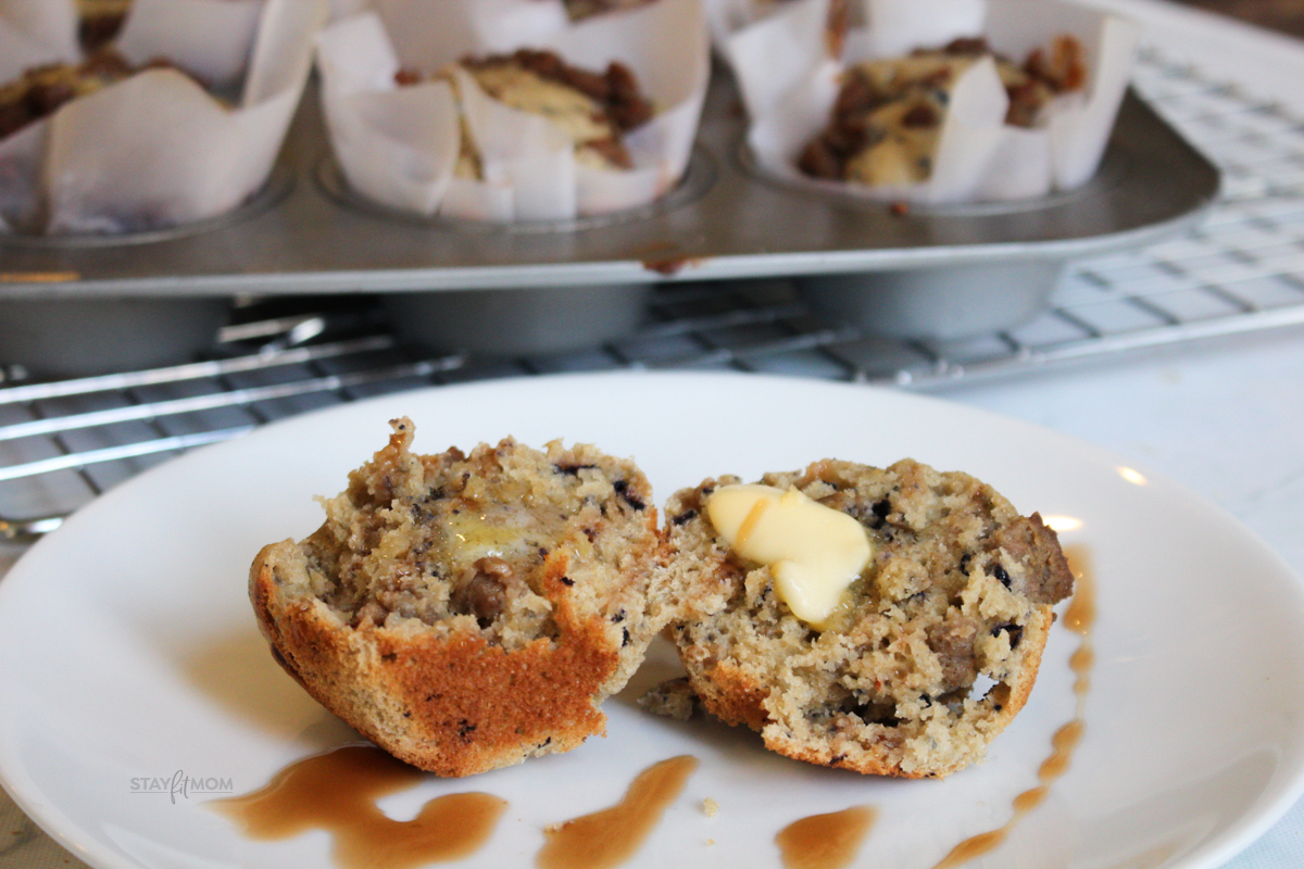 Sausage blueberry muffins showed cooked muffin cut in with a pat of butter an drizzled with syrup.