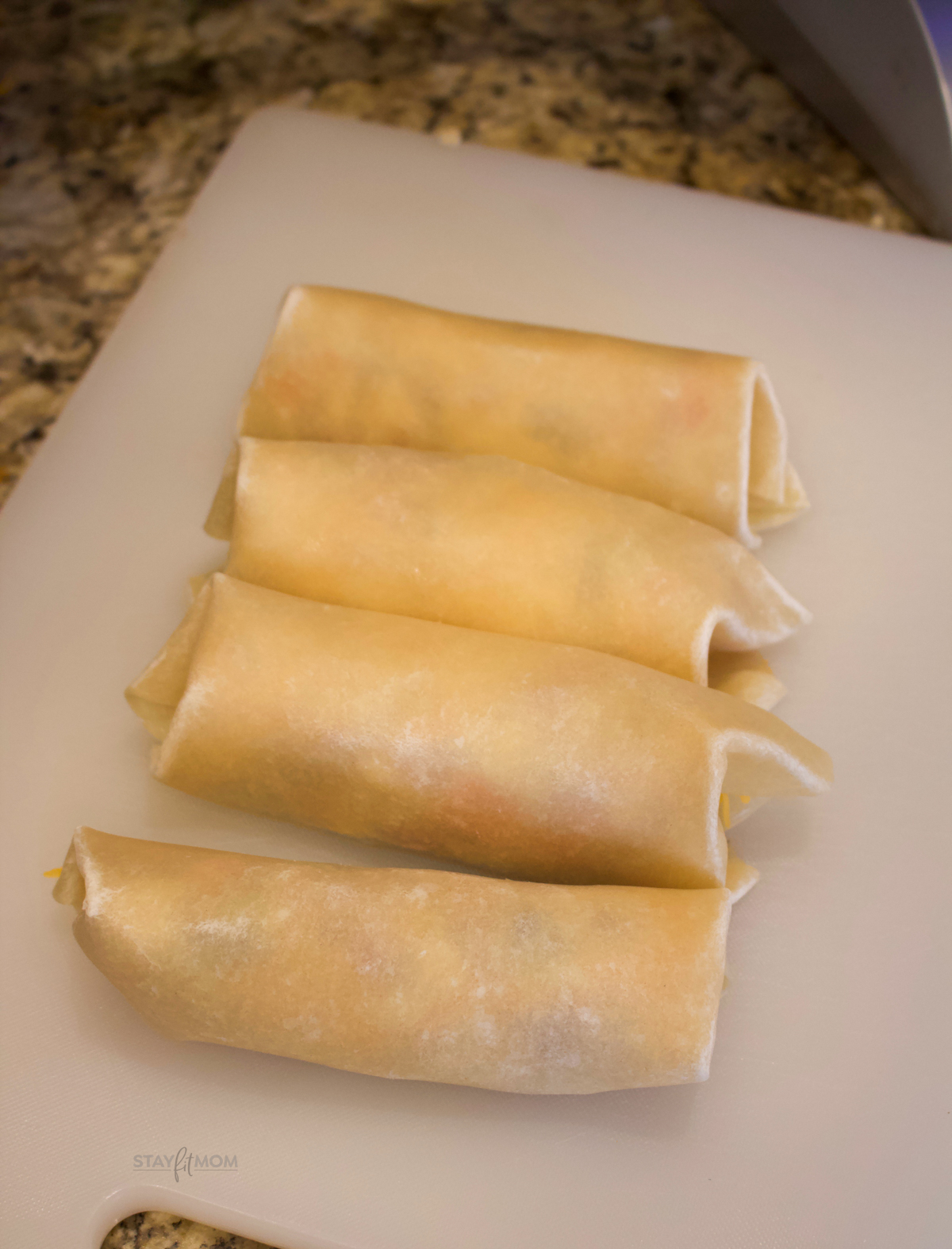 Meat Lovers Breakfast Burritos with rolled burritos ready to be cooked.