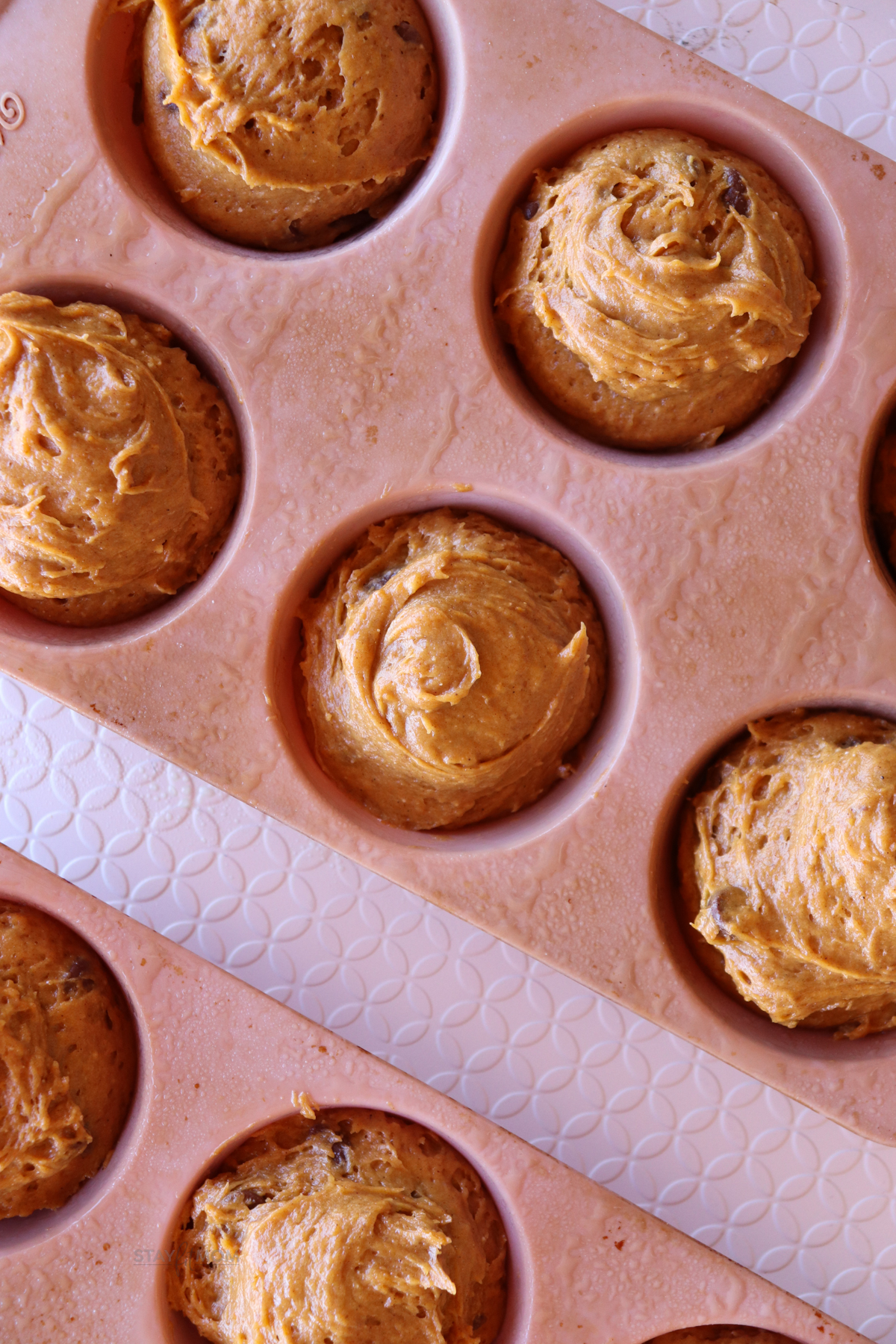 Pumpkin protein Muffins showing muffin pan with batter ready to be baked.