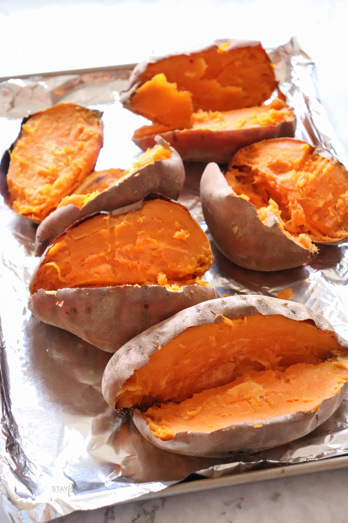 Sweet Potato Casserole showing sweet potatoes cut in half on a foil lined baking sheet.