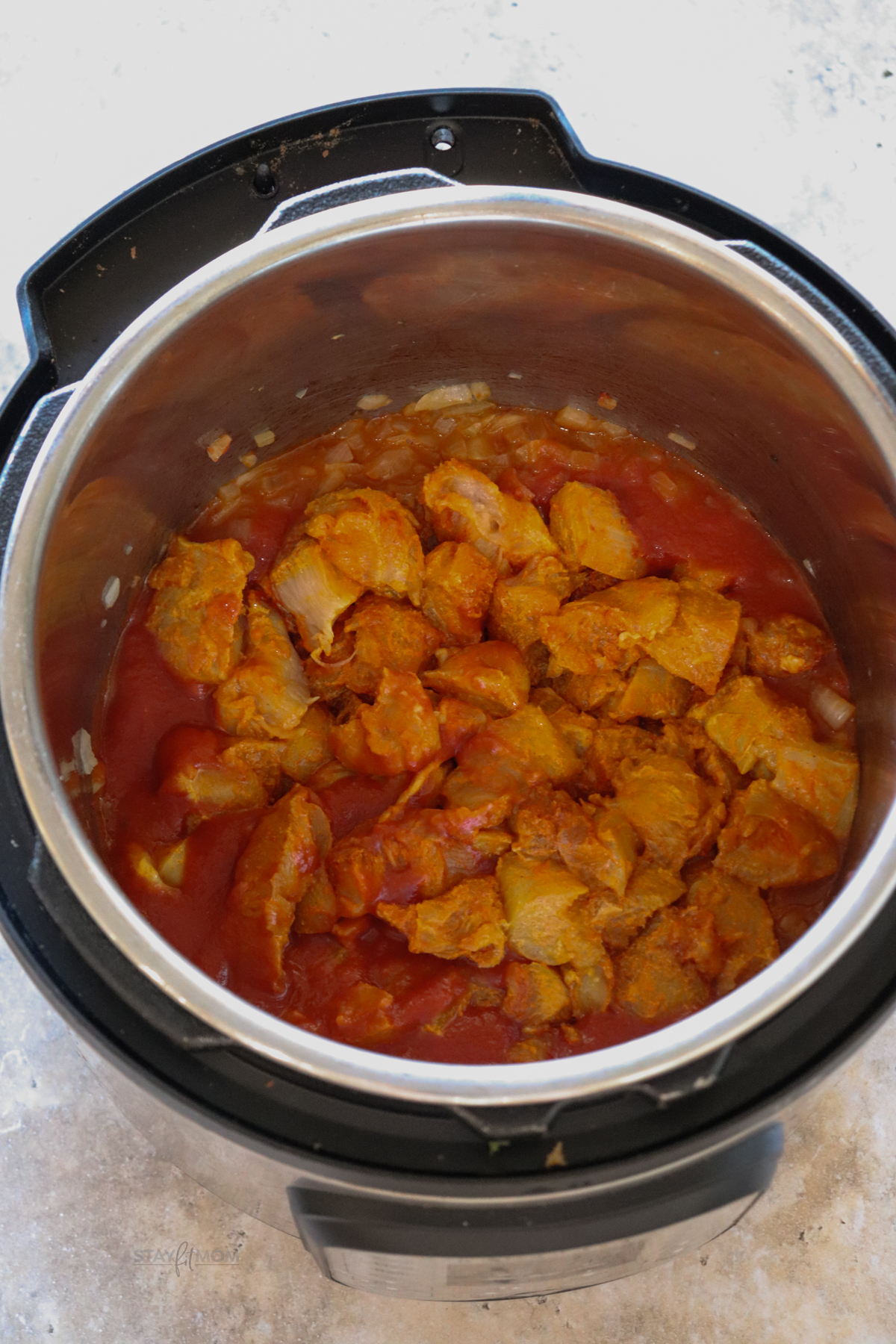 “Diced onions sautéing in olive oil to build the base for creamy chicken tikka masala.”