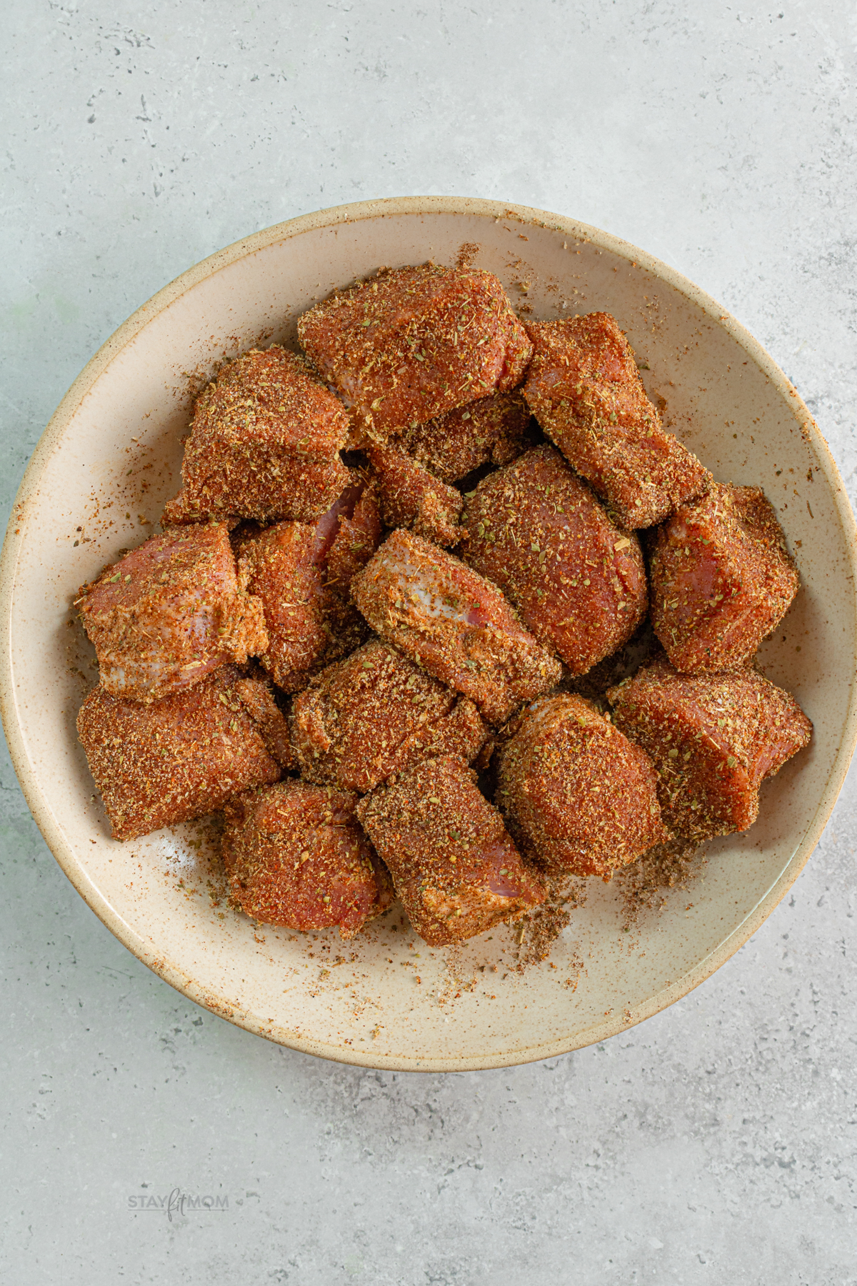 Pork loin pieces coated in seasoning and seared in a hot pan to build flavor for pork enchiladas.