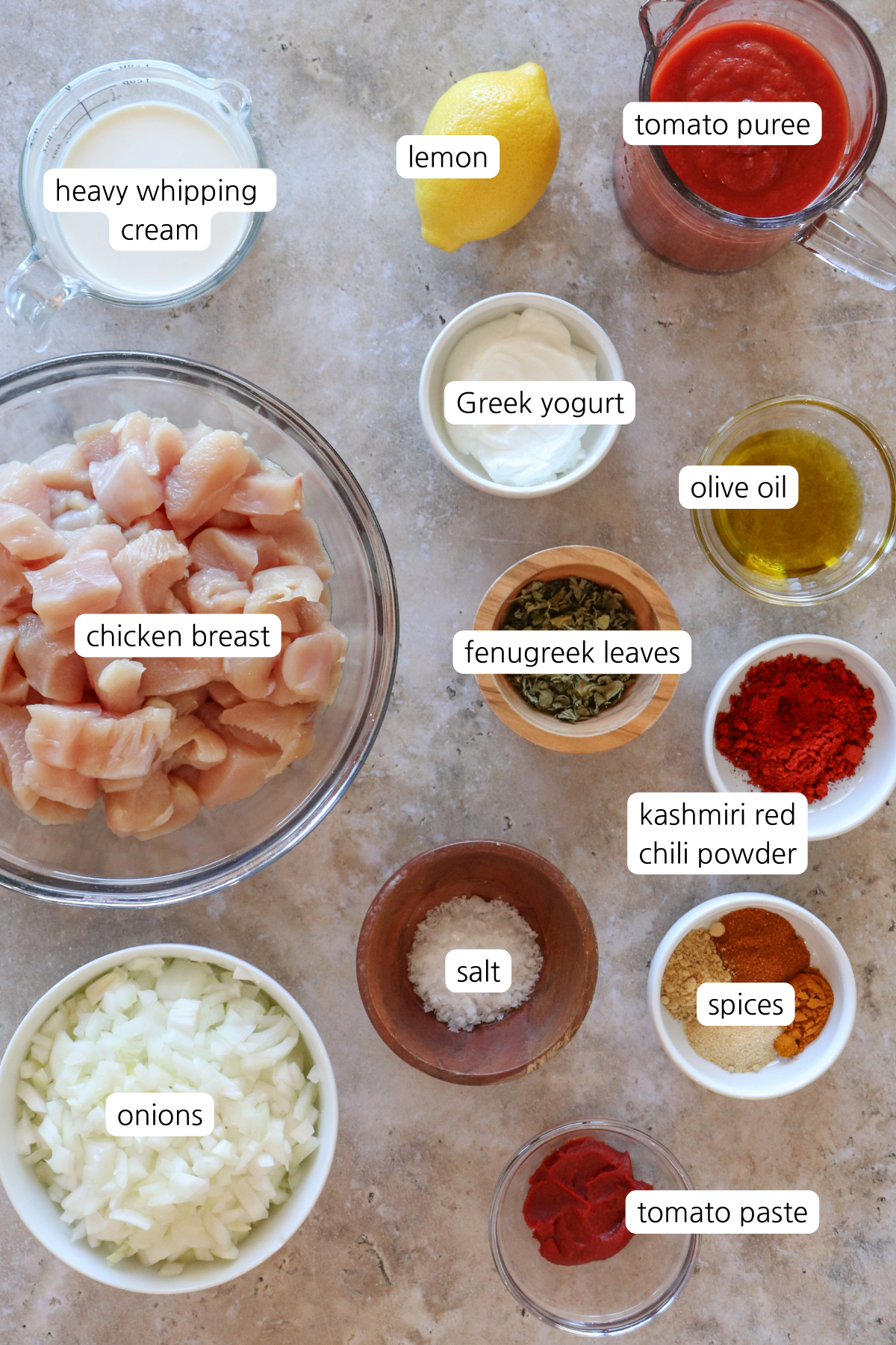 “Ingredients for homemade tikka masala including chicken breast, onions, Greek yogurt, garam masala, Kashmiri chili powder, tomato purée, and fenugreek leaves.”