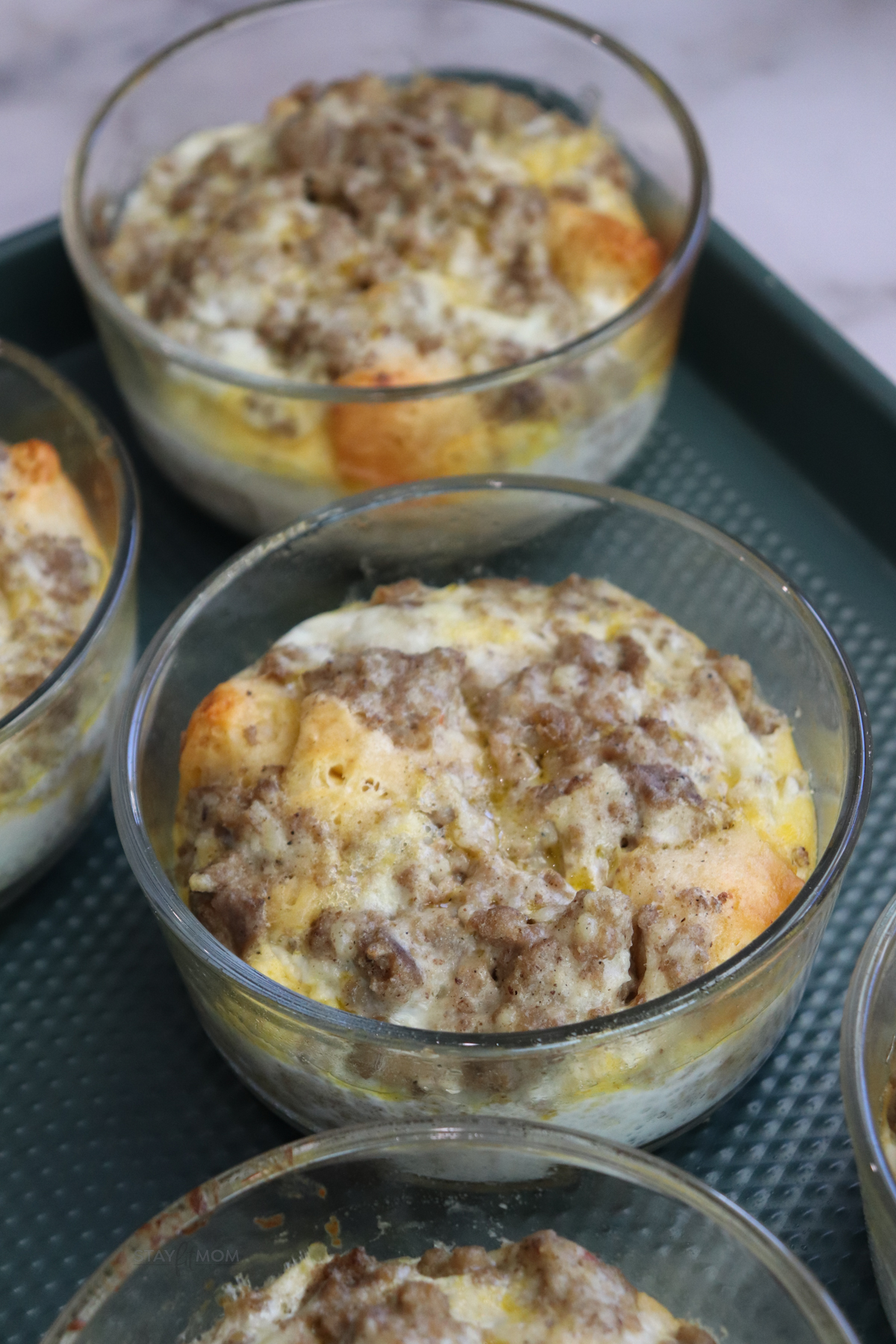 Meal prepped biscuit and gravy breakfast bowls ready for the week in oven-safe containers.