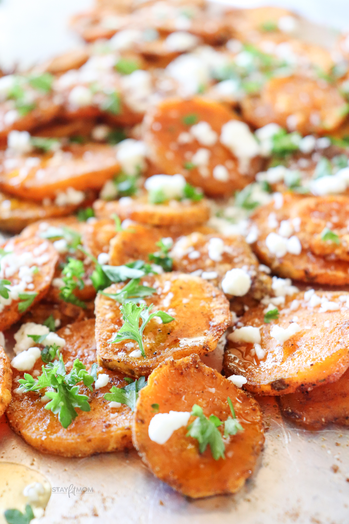 Honey roasted sweet potato rounds showing finished recipe with roasted sweet potatoes, topped with a glaze, feta, and some parsley.
