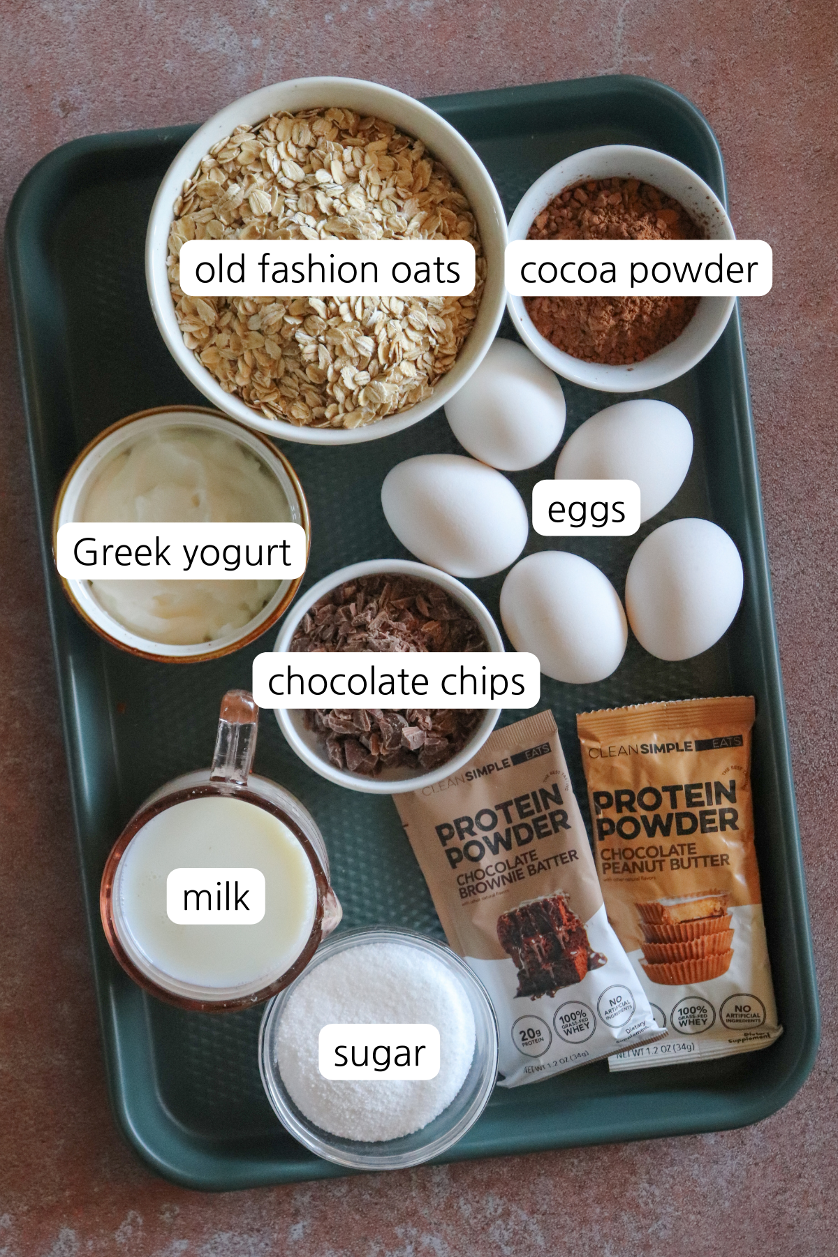 Chocolate baked oats showing small bowls labeled with ingredients on a small baking sheet.