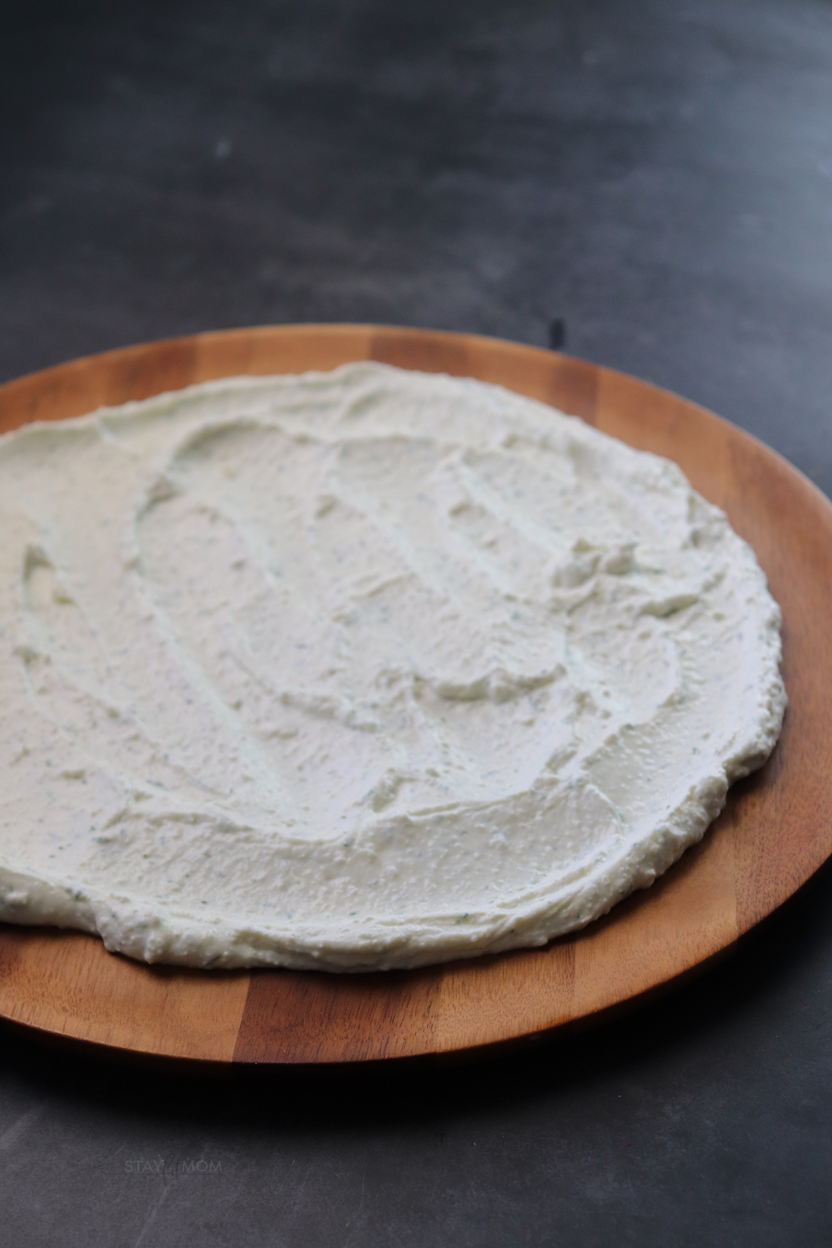Feta mixture whipped and spread on a shallow wooden platter.