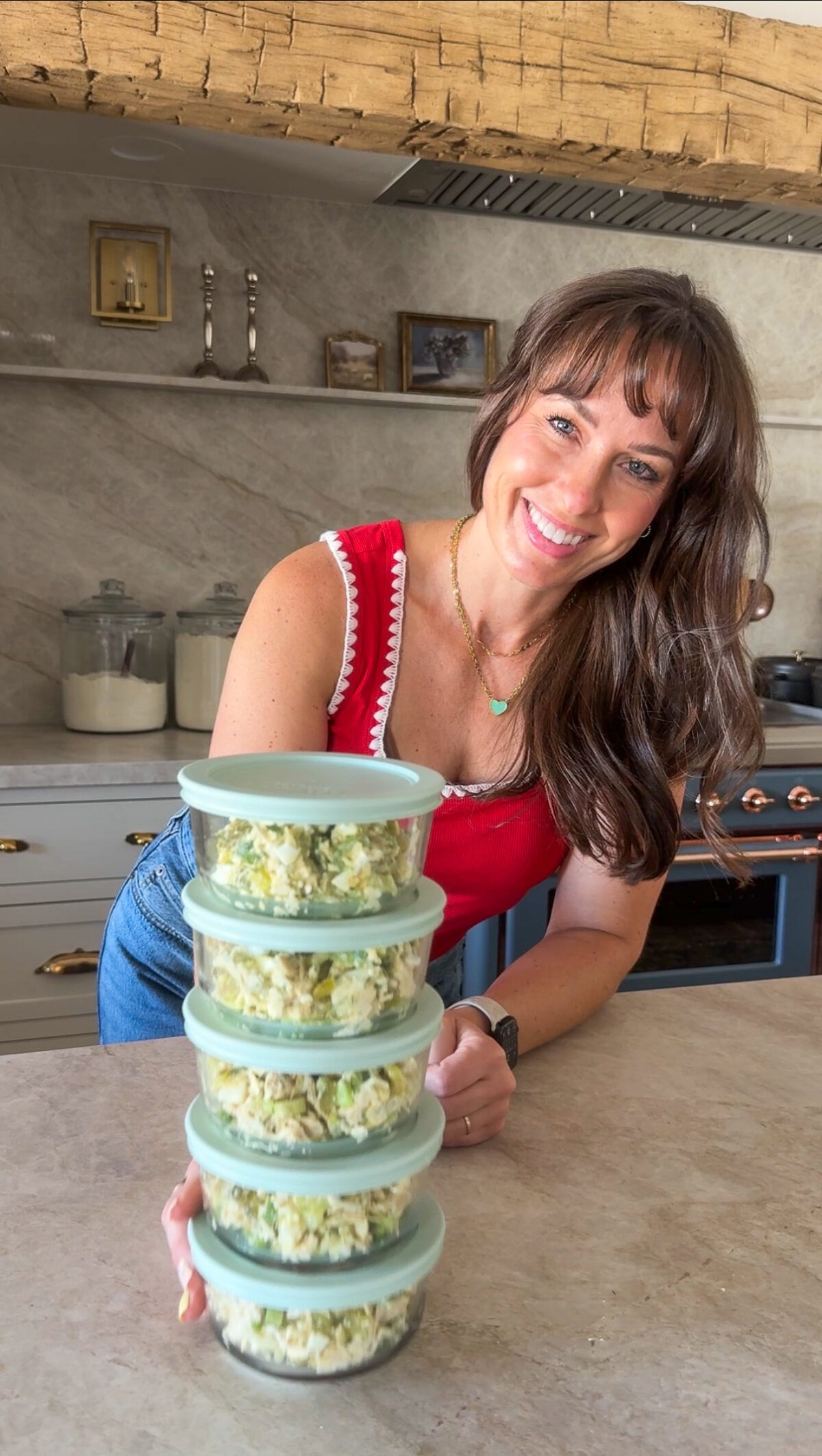Image of Krista standing behind 5 bowls of Dill Chicken Salad stacked up and ready for the week.