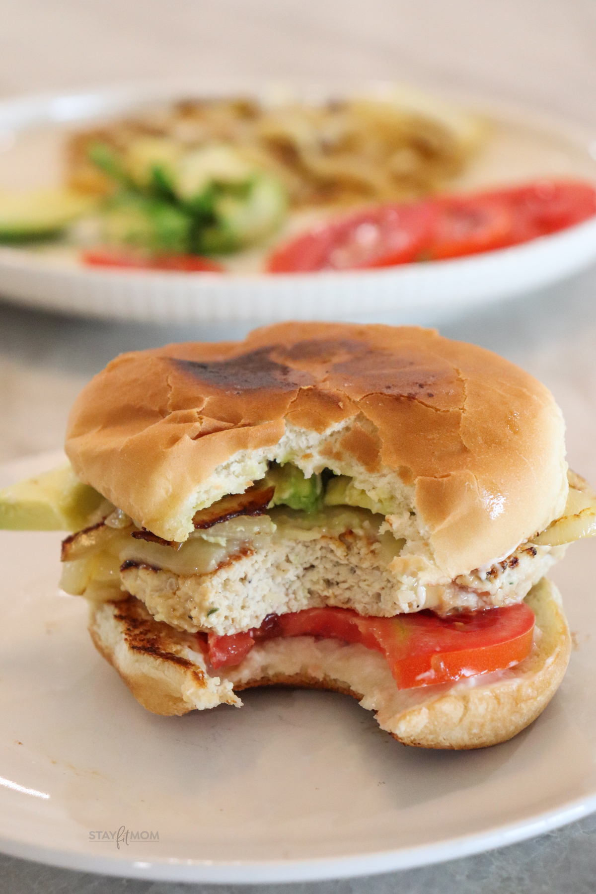 Chicken Patties showing completed burger on a bun with a bite out of it.