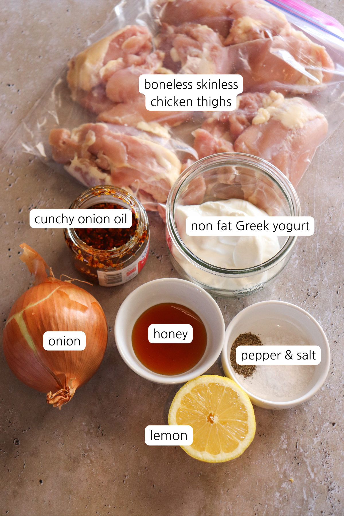 Crunchy onion loaf pan chicken showing labeled ingredients: boneless skinless chicken thighs, crunchy onion oil, nonfat Greek yogurt, onion, honey, lemon, salt and pepper.