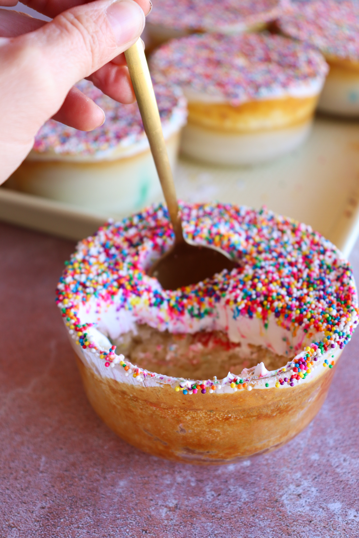 Dot Pancake Bowls showing a finished pancake bowl topped with Cool whip and sprinkles with a spoon ready to take the perfect bite.
