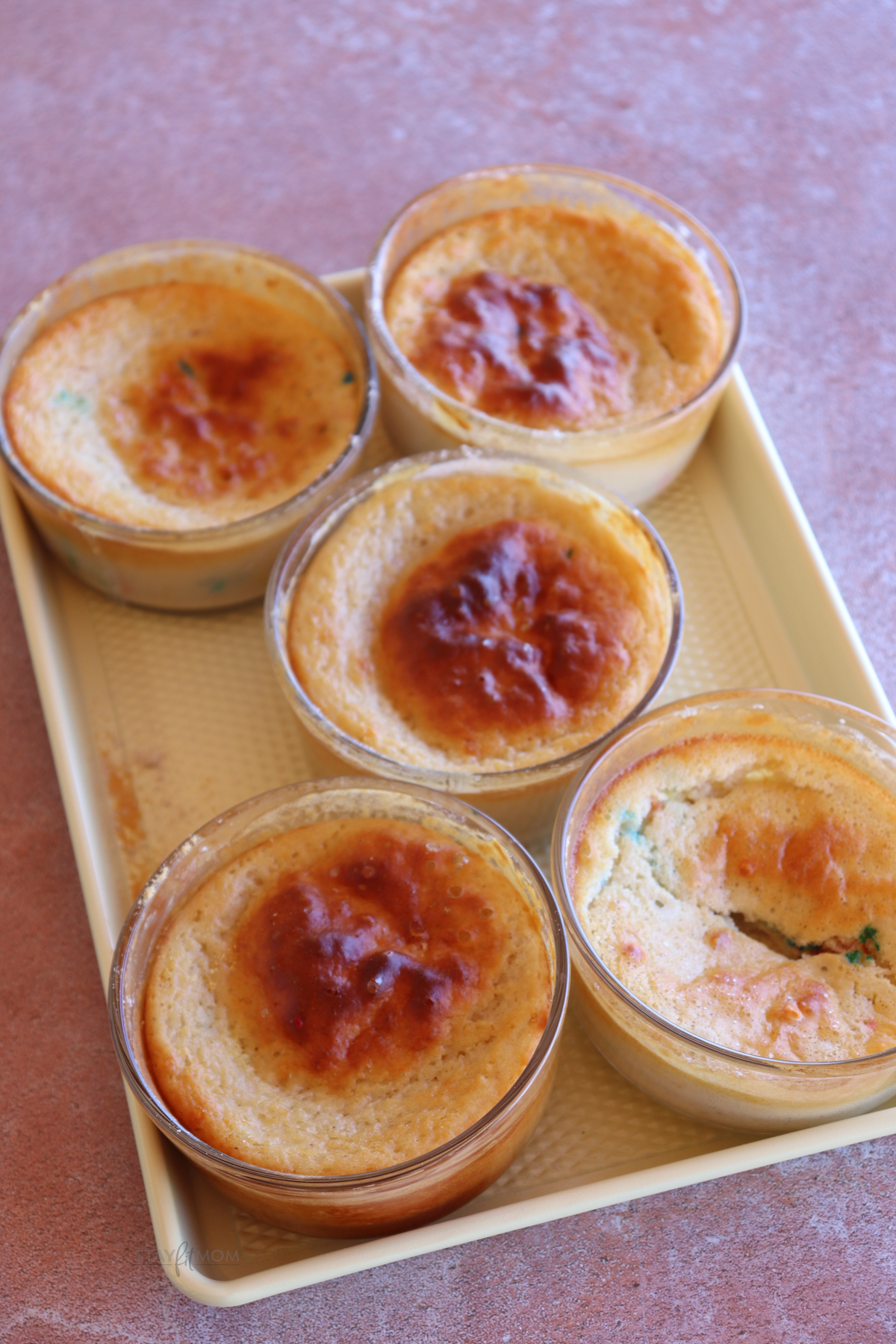 Dot Pancake Bowls showing 5completed pancakes baked in glass dishes on a baking sheet.