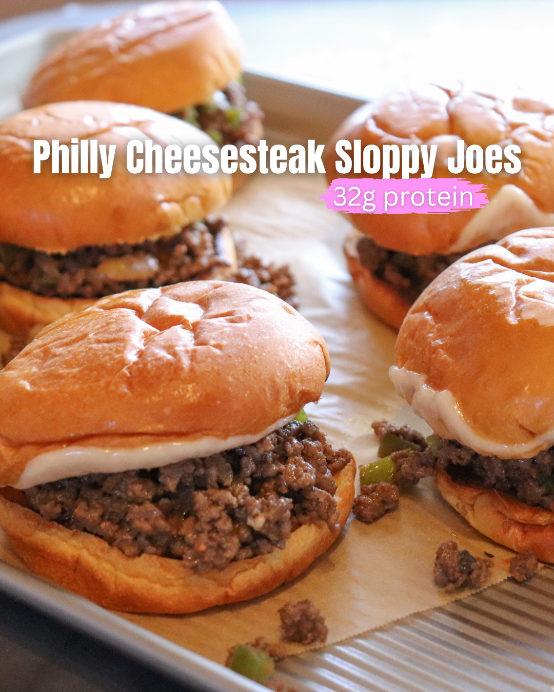 Philly Cheesesteak Sloppy Joes showing 5 buns filled with sloppy joe mix and melted cheese on a parchment lined pan.