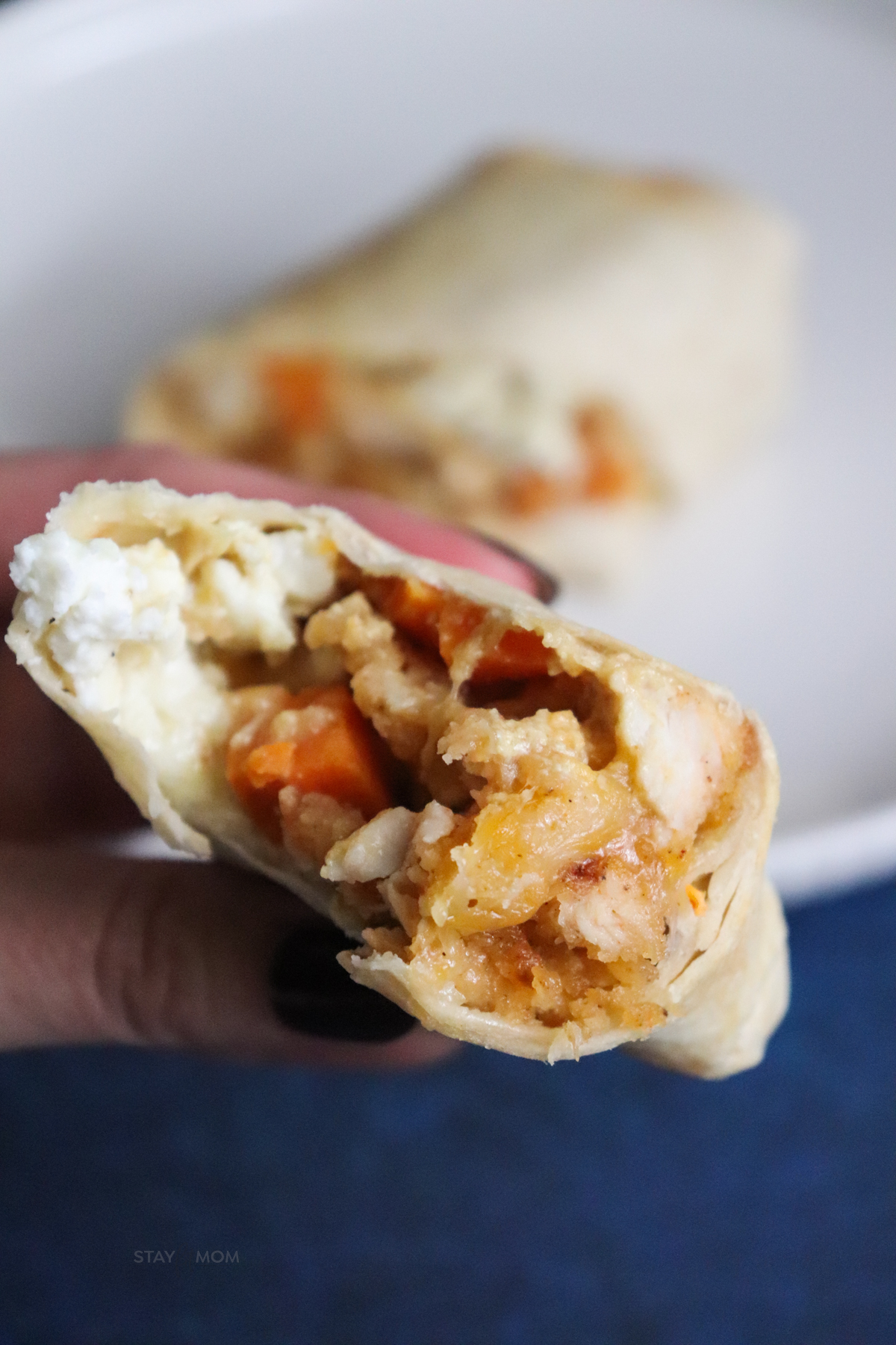 Close up of a crispy chicken burrito cut in half to show filling.