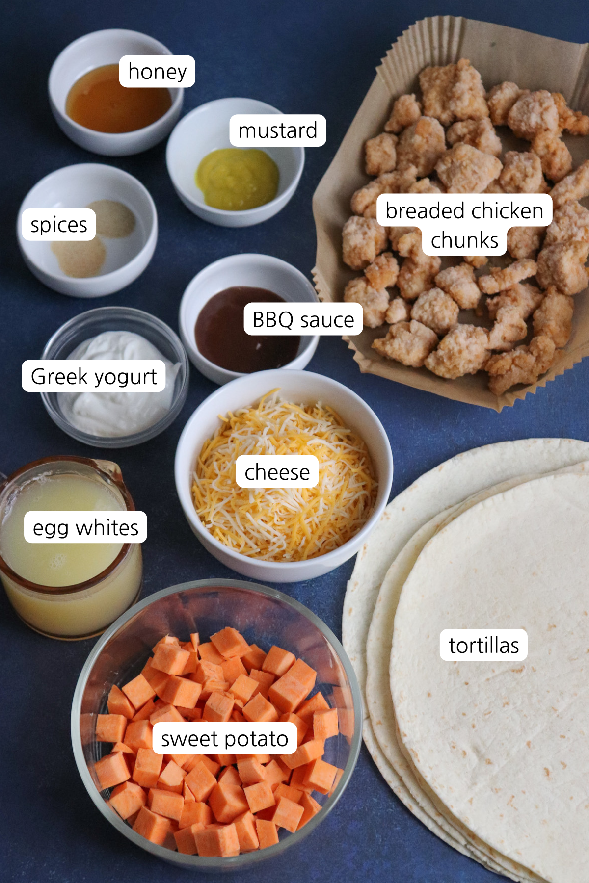 Crispy chicken breakfast burritos showing ingredients labeled in small bowls