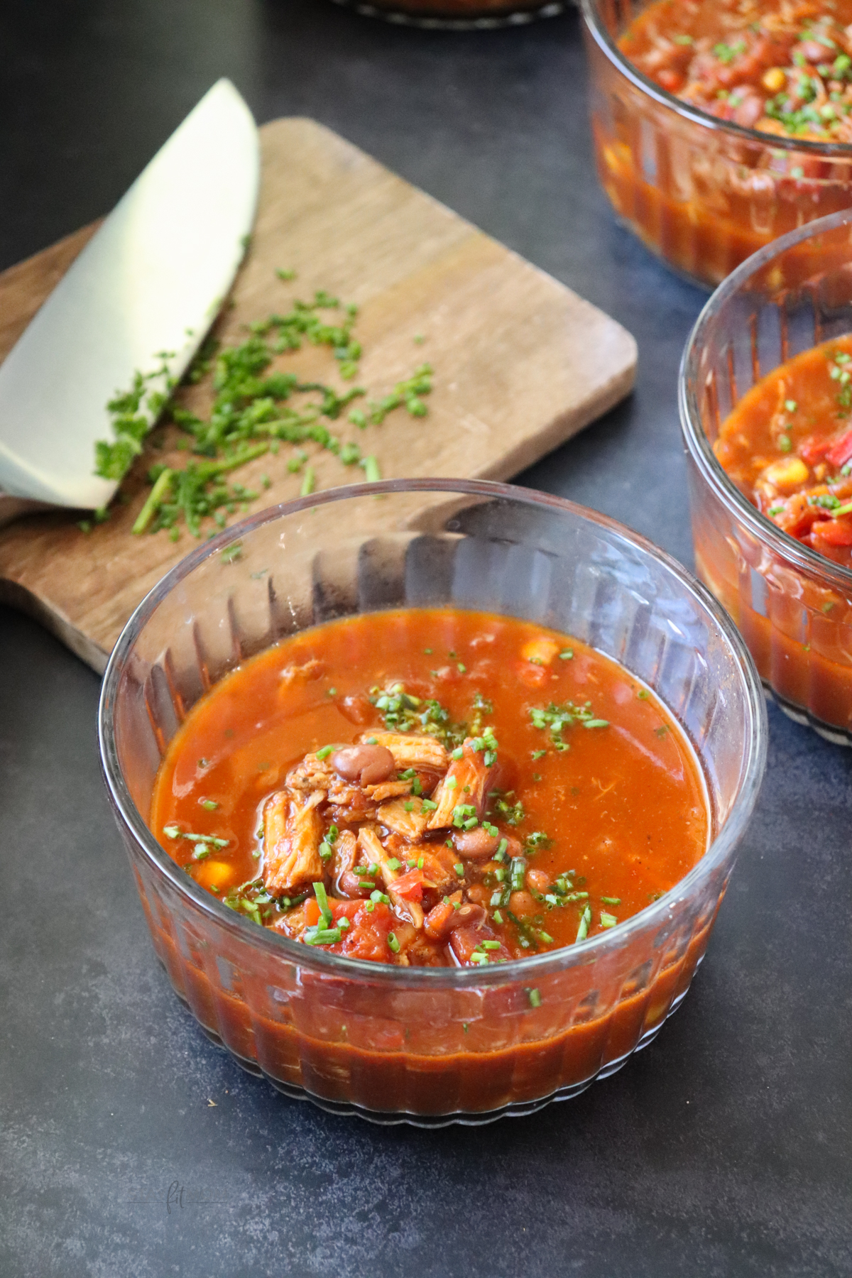 Pulled Pork Chili showing small glass bowls filled with the chili and topped with chives.