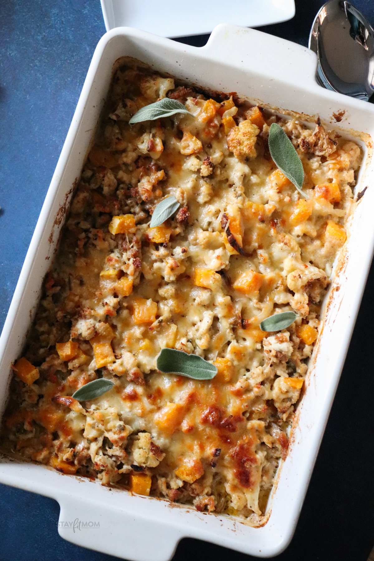 Sausage Butternut Casserole showing completed recipe in a white pan with visible sausage, butternut squash, sauce, and cheese.