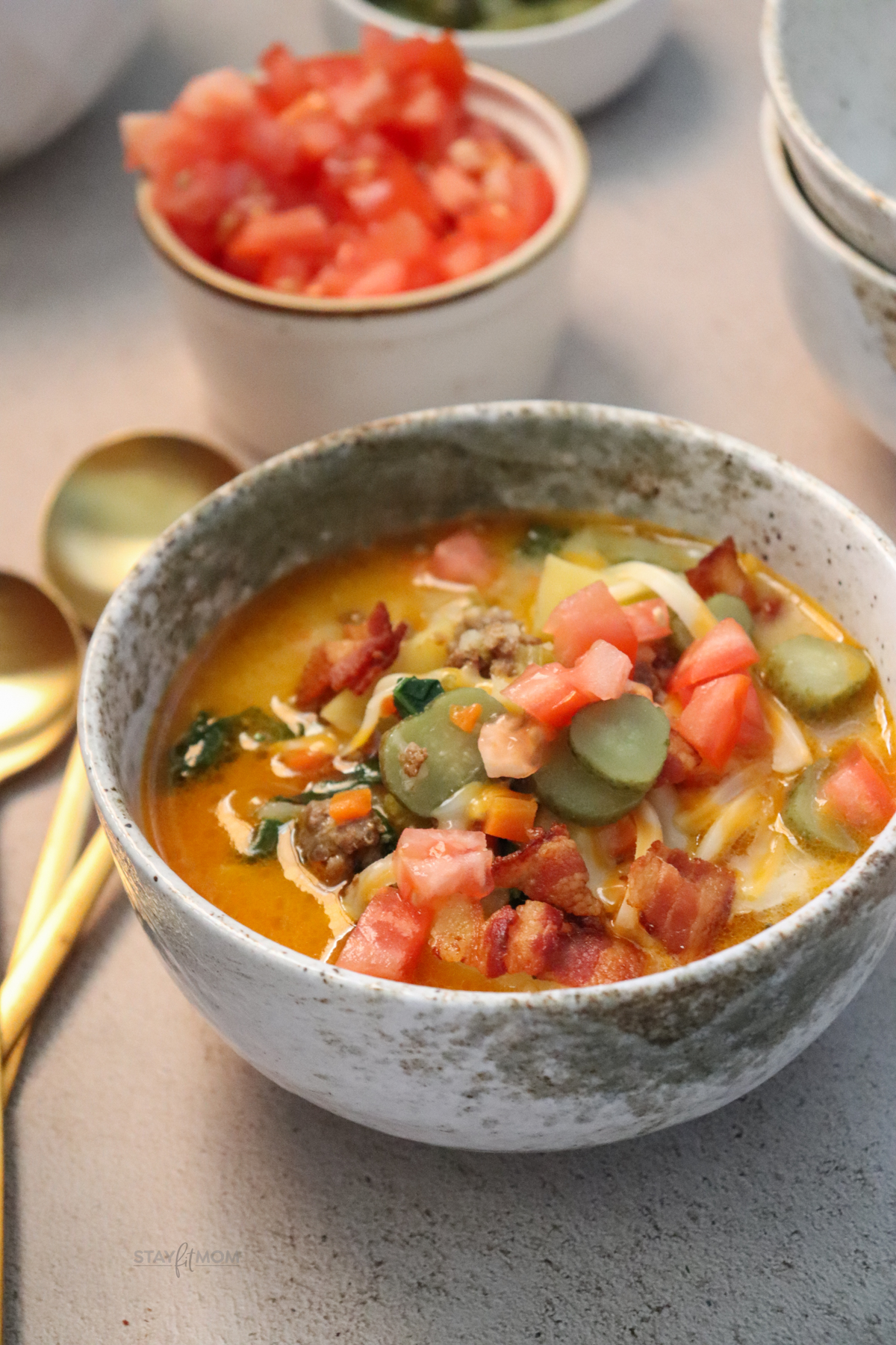 Cheeseburger soup showing finished recipe with visible ground beef, broth, spinach, cheese, and toppings.