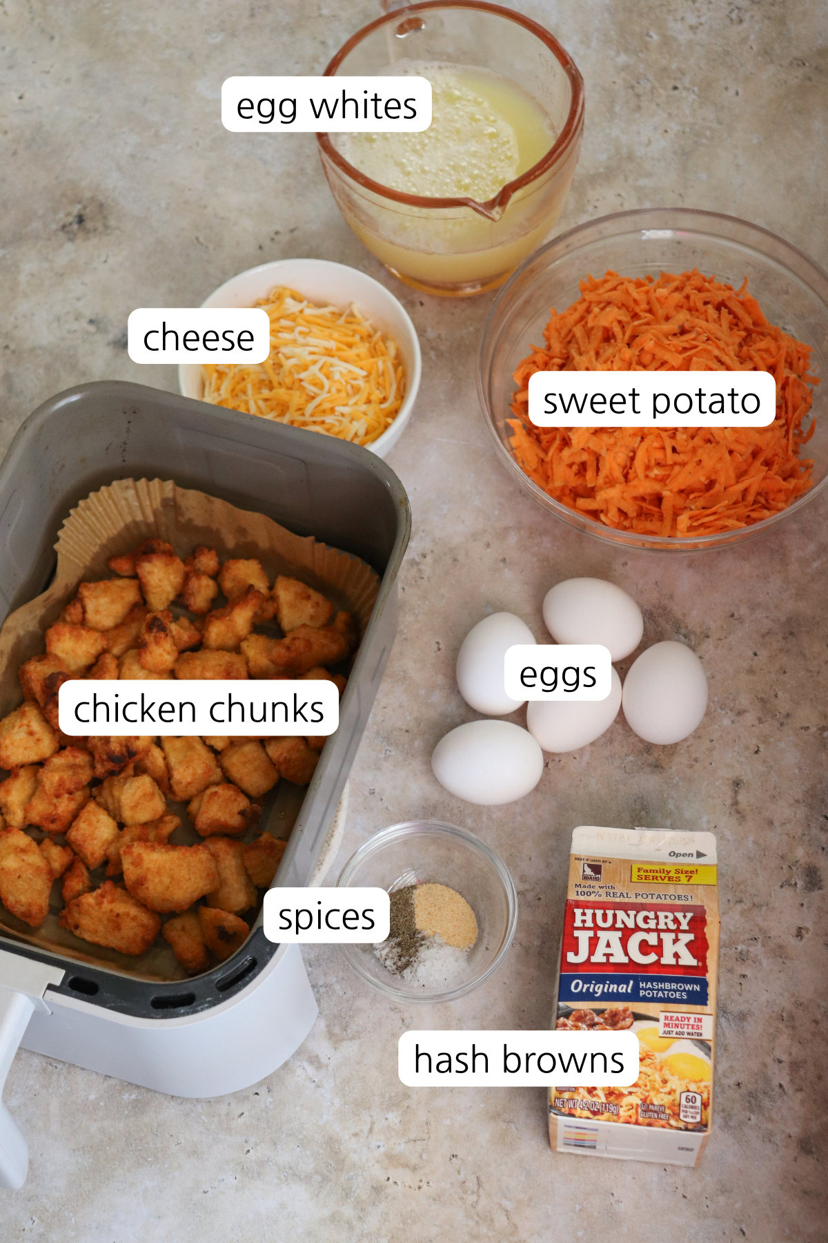 Chicken Chunk Scramble Bowls showing labeled ingredient: chicken chunks, hash browns, spices, eggs, sweet potato, cheese, and egg whites.
