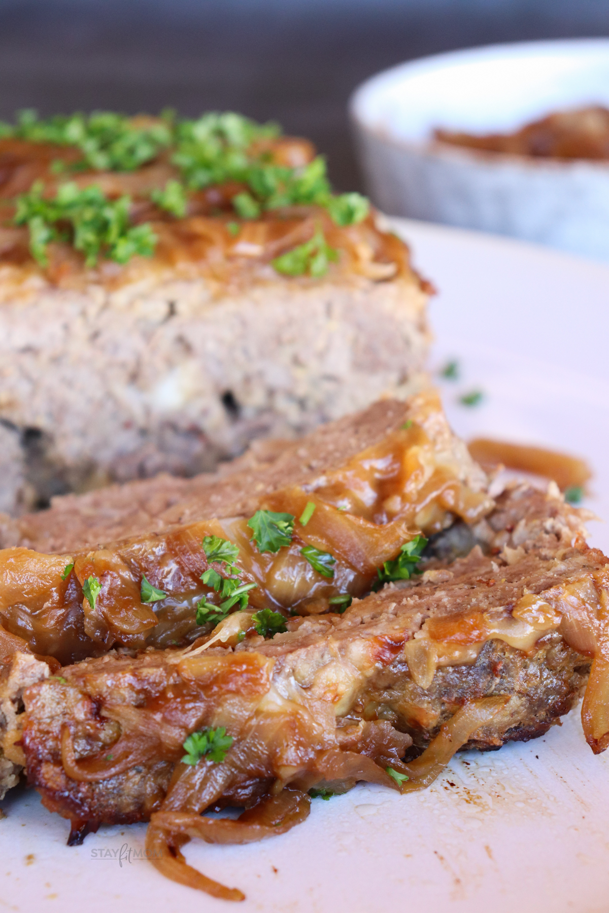 French Onion Meatloaf showing sliced meatloaf topped with caramelized onions.