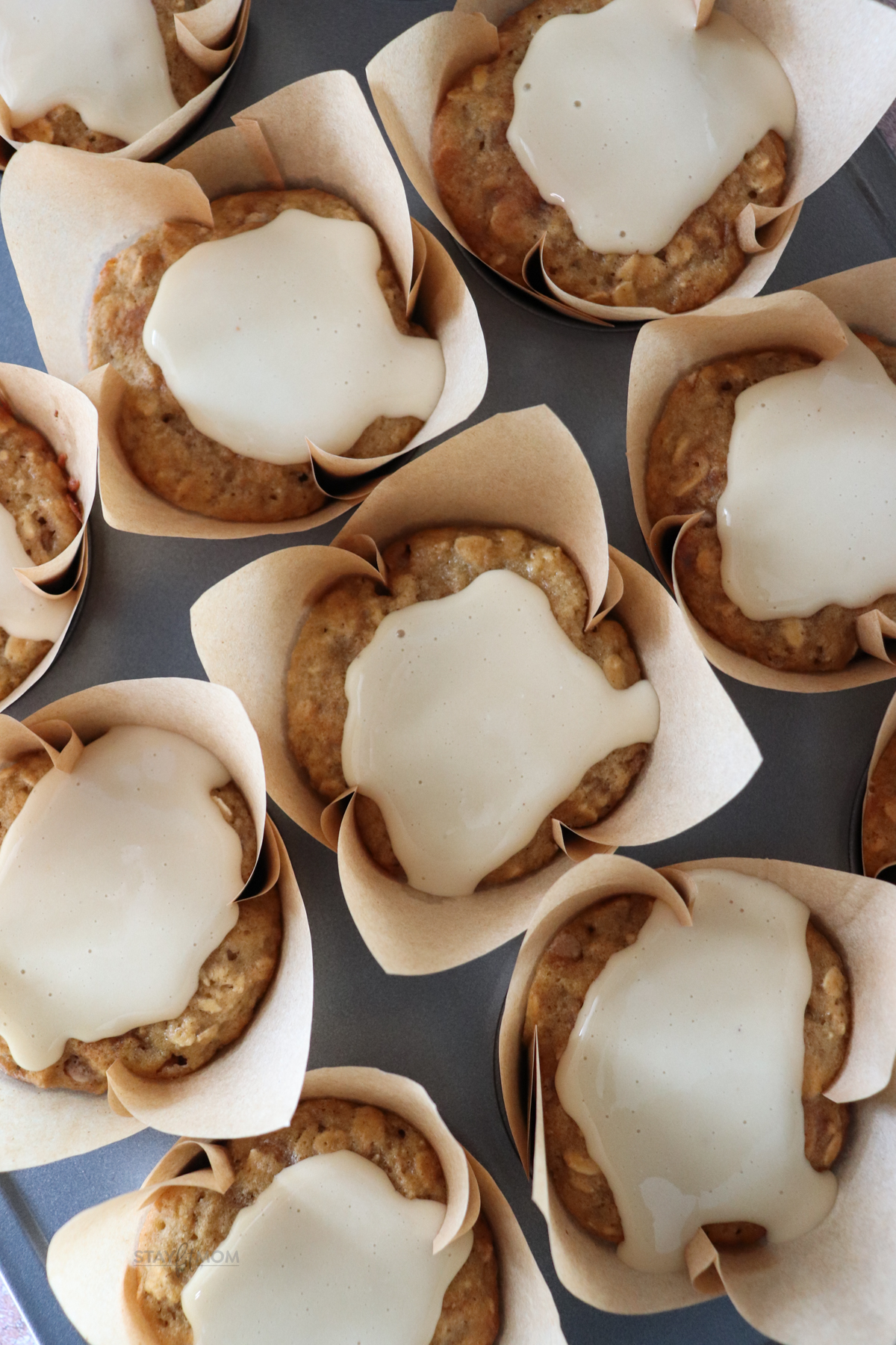 Maple Cinnamon muffins showing baked muffins in paper topped with glaze.