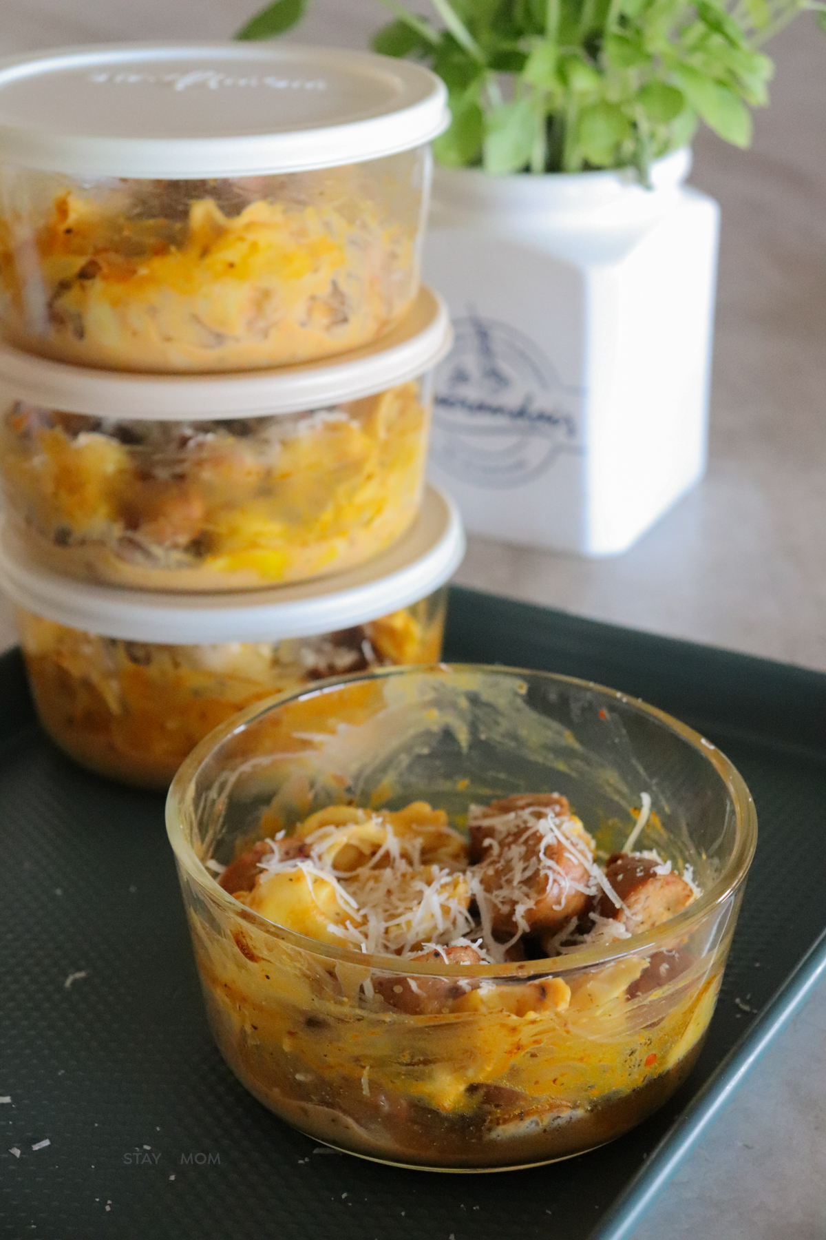 3 meal prep bowls stacked in the back and one in the front showing completed recipe.