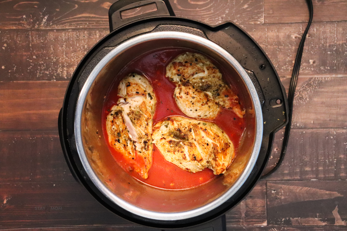Marry Me Chicken showing an Instant Pot with browned chicken breast in red sauce.