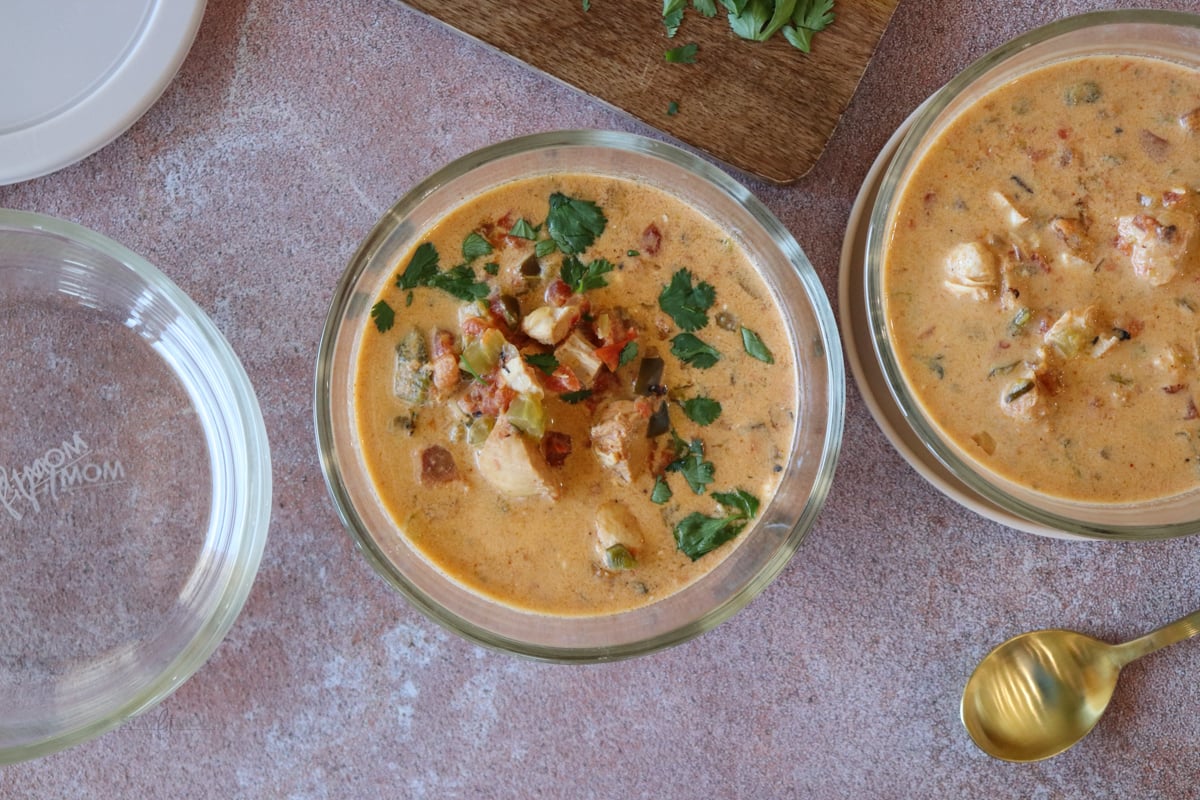 3 class bowls, two filled with soup with a gold spoon nearby.